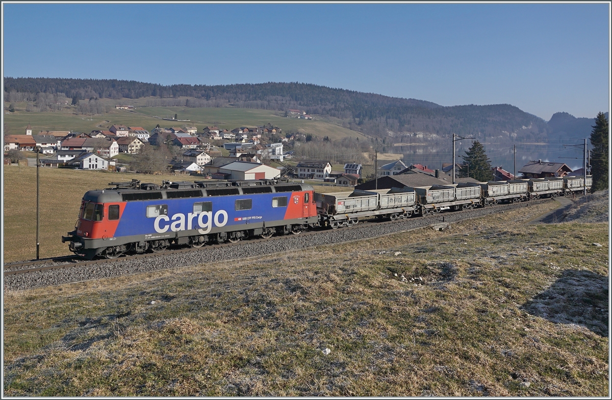 Die SBB Re 6/6 11610 (Re 620 010-9)  Spreitenbach  bringt etliche leere Fans-u Wagen als Güterzug 69701 von Lausanne-Triage nach Le Brassus und konnte hier bei Les Charbonnières mit dem Hintergrund des Lac de Brenet fotografiert werden. 

24. März 2022