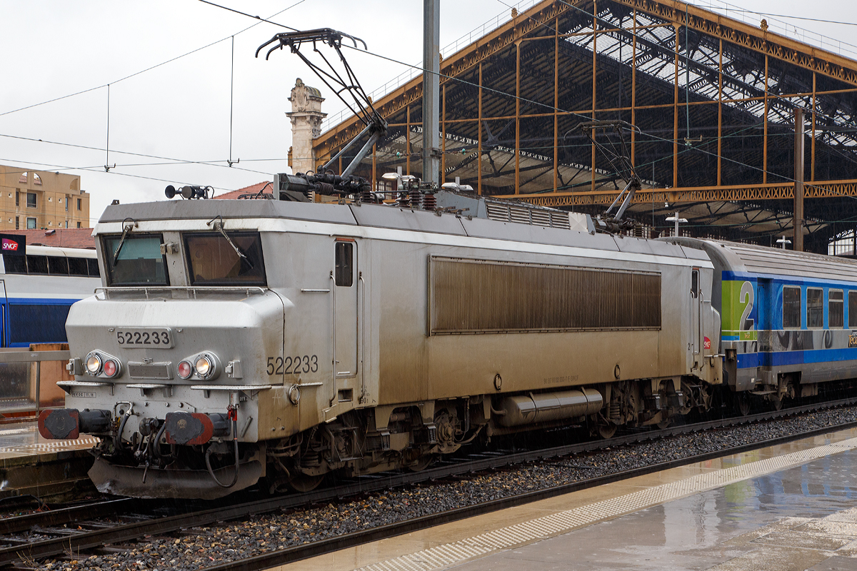 Die SNCF   nez cass� en livr�e grise  (zu deutsch  gebrochene Nase in  grauer Farbgebung ) BB 22233 (91 87 0022 233- 7 F-SNCF) steht am 25.03.2015 mit einem Corail T�oz (Intercity) im Bahnhof Marseille St-Charles zur abfahrt bereit.  An Hand der ersten Ziffer vor der Loknummer (5), kann man die die Zugeh�rigkeit zum Gesch�ftsbereich der SNCF erkennen, die  5  steht f�r TER (Regionalverkehr).

Die BB 22200 ist eine Zweissystemlokomotive f�r den Einsatz sowohl auf dem mit 1,5 kV elektrifizierten Gleichstromnetz der SNCF als auch auf dem mit 25 kV 50 Hz elektrifizierten Wechselstromnetz. In den Jahren 1976 bis 1986 wurden von Alsthom in sechs Bauserien insgesamt 205 Lokomotiven gebaut.

In den 1970er-Jahren ben�tigte die SNCF neue Mehrsystemlokomotiven, um unter beiden Stromsystemen ohne Lokwechsel fahren zu k�nnen. Aus der ab 1971 gelieferten Baureihe BB 15000 und der ab 1976 gebauten Gleichstrombaureihe BB 7200 wurde die BB 22200 als Mehrsystemvariante entwickelt. Die Baureihenbezeichnung bildet die Summe aus denen der beiden Schwesterbauarten.

Technische Daten:
Gebaute St�ckzahl: 205
Hersteller: Alstom
Baujahre: 1976–1986
Achsformel: B'B'
L�nge �ber Puffer: 17.480 mm
Achsabstand im Drehgestell: 2.800 mm
Drehzapfenabstand: 9.694 mm
Dienstmasse: 90 t
Triebraddurchmesser (neu): 1.250 mm
H�chstgeschwindigkeit: 160 km/h (wenige umgebaute 200 km/h)
Dauerleistung: 4.360 kW
Stromsystem: 25 kV/50 Hz AC, 1,5 kV DC
Anzahl der Fahrmotoren: 2 (TAB 674)