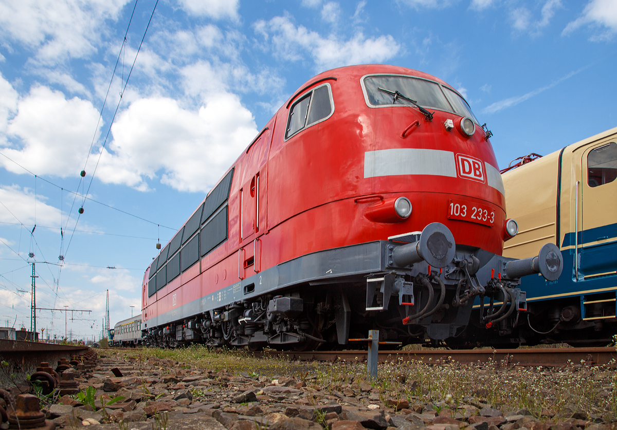 Die stärkste deutsche Lok – Baureihe und einzige Maschine der Baureihe in verkehrsrotem Farbschema, die DB 103 233-3 , am 09.04.2016 beim DB Museum Koblenz-Lützel. Da sie vor dem Tor stand, musste ich meine Kamera unter das Tor halten.

Die 103 233-3 wurde 1973 von Henschel in Kassel unter der Fabriknummer 31780 gebaut, der elektrische Teil ist von BBC (Brown, Boveri & Cie AG). Auf  Initiative vom Modelleisenbahnhersteller Roco wurde sie in verkehrsrot lackiert und so am 5. August 2000 offiziell vorgestellt.

Die Baureihe 103 (Anfangs: E 03) sind schwere sechsachsige Elektrolokomotiven, die im schnellen Reisezugverkehr der Deutschen Bundesbahn (DB) eingesetzt wurden, sie waren lange das Flaggschiff der DB. Mit ihrer Dauerleistung von 7.440 kW (10.116 PS) waren die E 03 bei ihrer Indienststellung die stärksten einteiligen Lokomotiven der Welt und sind die leistungsstärksten Lokomotiven, die die Deutschen Bundesbahn je im Dienst hatte.