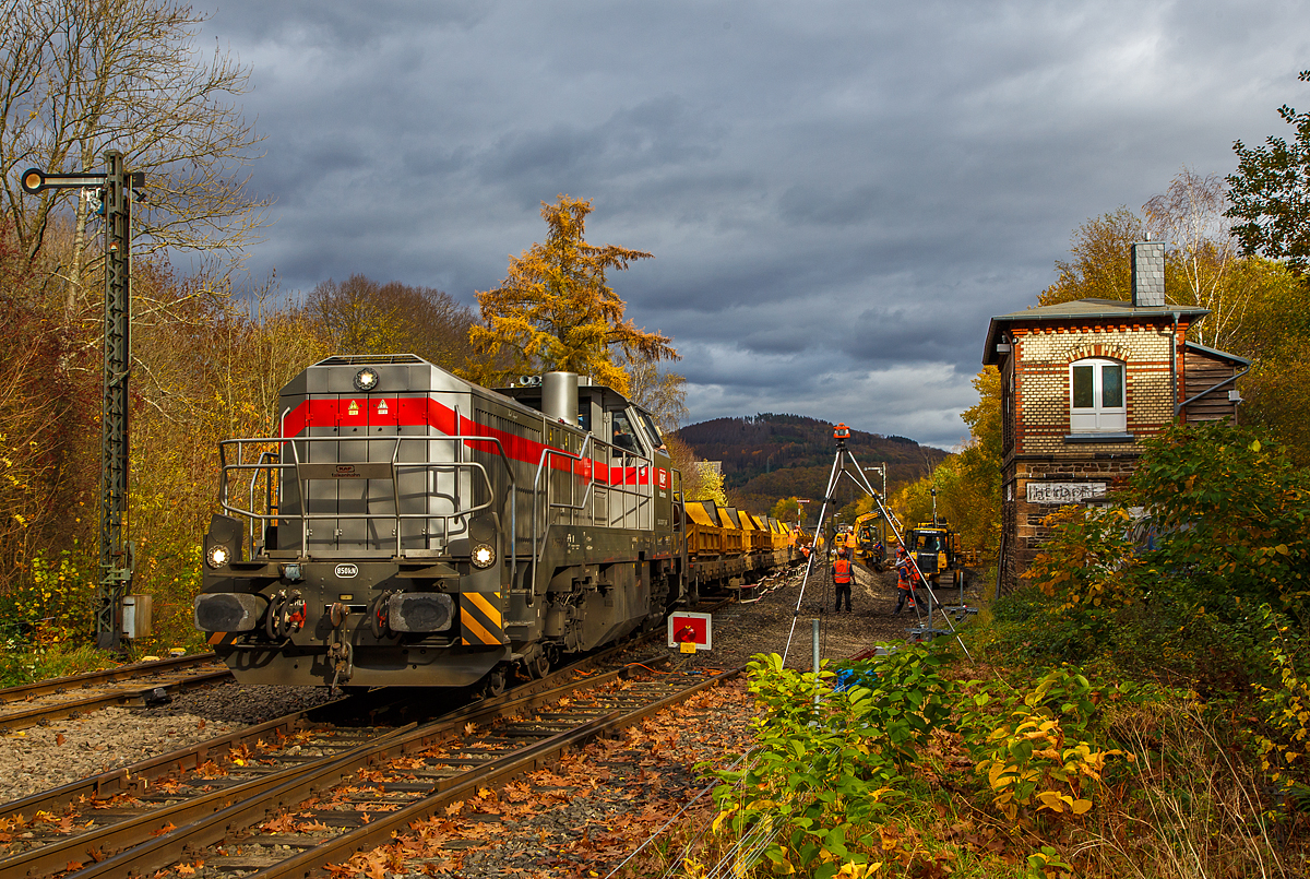
Die Vossloh G 12 – 4120 001-7 „Karl August“ (92 80 4120 001-7 D-KAF) der KAF Falkenhahn Bau AG (Kreuztal) steht am 02.11.2020 mit einem Kippwagenzug (Kippwagen MK 45 DH „LW-Kipper“, der Gattung Rlps) auf Gleis 2 im Bahnhof Herdorf. Der Zug wird von einem ZW-Bagger mit dem Aushub (Altschotter) von Gleis 4 beladen. Der Altschotter  wird später zum Recycling nach Bochum abgefahren.  

Rechs das Stellwerk Herdorf Fahrdienstleiter (Hf).

Übrigens, die Lok trägt den Namen des Firmengründers Karl August Falkenhahn, der die Baufirma 1919 in Kreuztal gründete.