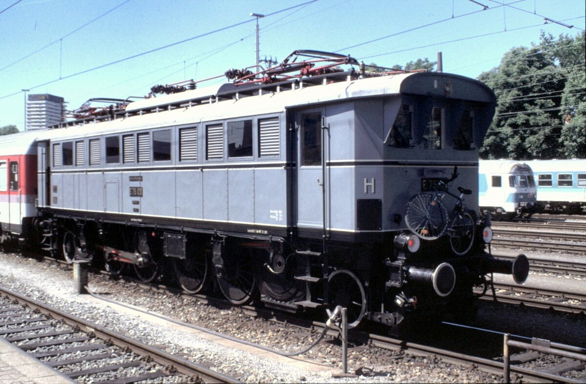E 75 09 in Ulm auf dem Weg zu einer Ausstellung am 15.06.1996, an einem IC angehängt. Der Lokführer hat sein Fahrrad mitgenommen für die Freizeit und an die Lok angebunden.