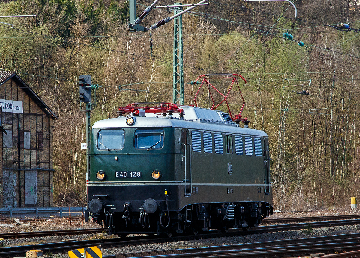 Eigentlich ist Karfreitag, aber es fährt trotzdem viel und außergewöhnliches auf der Siegstrecke...
Im Ursprungszustand die E 40 128 bzw. 140 128-0 (91 80 6 140 128-0 D-DB) vom DB Museum fährt am 02.04.2021, als Tfzf (Triebfahrzeugfahrt) bzw. Lz (Lokzug), durch Betzdorf (Sieg) in Richtung Siegen. Die Lok war auf dem Weg nach Crailsheim.

Die Lok wurde 1959 von Krauss Maffei unter der Fabriknummer 18539 gebaut, der elektrische Teil ist von den Siemens Schuckertwerke, und an die Deutschen Bundesbahn als E40 128 geliefert. Zum 01.01.1968 erfolgte die Umzeichnung in DB 140 128-0. Aus dem aktiven Dienst schied sie 2005 aus und ging ins DB Museum Koblenz-Lützel. Die Lok befindet sich als E40 128 im Ursprungszustand (chromoxidgrün)

Die ab dem Jahr 1968 als Baureihe 140 geführten Loks sind technisch gesehen eine E 10.1 ohne elektrische Bremse, jedoch mit geänderter Übersetzung des Getriebes.
Mit 879 Exemplaren ist die E 40 die meistgebaute Type des Einheitselektrolokprogramms der Deutschen Bundesbahn. Ihre zulässige Höchstgeschwindigkeit betrug am Anfang entsprechend ihrem vorgesehenen Einsatzgebiet im mittelschweren Güterzugdienst 100 km/h, diese wurde im Juni 1969 jedoch auf 110 km/h erhöht, um die Züge zu beschleunigen und die Loks auch besser im Personen-Berufsverkehr einsetzen zu können.

TECHNISCHE DATEN:
Spurweite: 1.435 mm
Achsanordnung: Bo´Bo´
Länge über Puffer: 16.440 mm
Drehzapfenabstand: 7.900 mm
Achsstand in den Drehgestellen: 3.400 mm
Gesamtachsstand: 11.300 mm
Treibrad-Durchmesser: 1.250 mm
Dienstgewicht:  86t
Achslast: 21,5t
Zulässige Höchstgeschwindigkeit: 110 Km/h
Stromsystem: Einphasen-Wechselstrom 15 000 V, 16 ²/₃ Hz
Nennleistung: 3.700 kW (5.032 PS)
Zugkraft: 336 kN
Nennleistung Trafo: 4040 kVA
Anzahl Fahrstufen:  28
Anzahl Fahrmotoren:  4
Fahrmotor-Typ: SSW WB 372

Beschaffungskosten:  ca. 1.226.000 DM