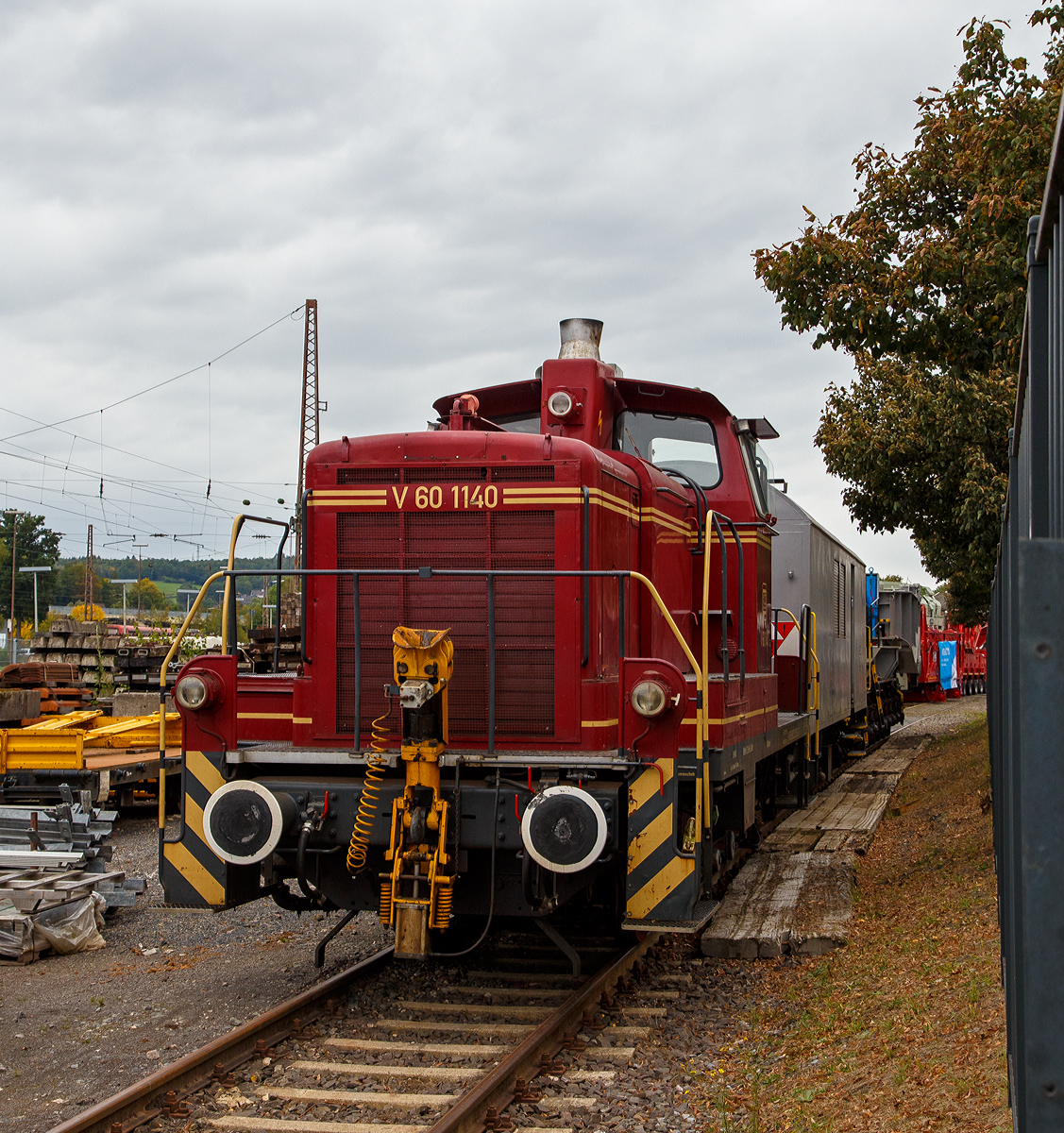 Eigentlich war heute kein Fotowetter, aber wir wollen doch mal raus und hatten Glück....
Die V 60 1140 (98 80 3 365 140-3 D-VEB) der VEB Vulkan-Eifel-Bahn (Gerolstein) steht am 03.10.2021 in Kreuztal auf dem Betriebsgelände der KAF Falkenhahn Bau AG (zum Glück ist der Zaun sehr weitmaschig) mit dem Tragschnabelwagen der Gattung Uaai 687.9 (84 80 996 0 003-5 D-AMPR) und dem Wohn-Werkstattwagen 440 (40 80 1501 002-3 D-AMPR) beide der Amprion GmbH.

Lebenslauf der V 60 (schwere Bauart):
Gebaut wurde die Lok 1963 von MaK in Kiel unter der Fabriknummer 600455 und als V 60 1140 an die Deutsche Bundesbahn geliefert. Zum 01.01.1968 erfolgte die Umzeichnung in DB 261 140-8. Im Jahr 1987 erfolgte ein  Umbau bzw. die Ausrüstung mit Funkfernsteuerung (Vorserie). Zum 01.10.1987 wurde sie zur Kleinlok und somit zur 361 140-7, da sie eine Funkfernsteuerung hatte wurde sie zum 01.01.1988 nun zur 365 140-3 umgezeichnet.  Bei der DB AG erfolgte 2005 die z-Stellung und 2006 letztendlich die Ausmusterung. Einige Zeit war sie bei der RSE Rhein-Sieg-Eisenbahn in Bonn-Beuel bis sie im Februar 2012 an die VEB Vulkan-Eifel-Bahn in Gerolstein ging.