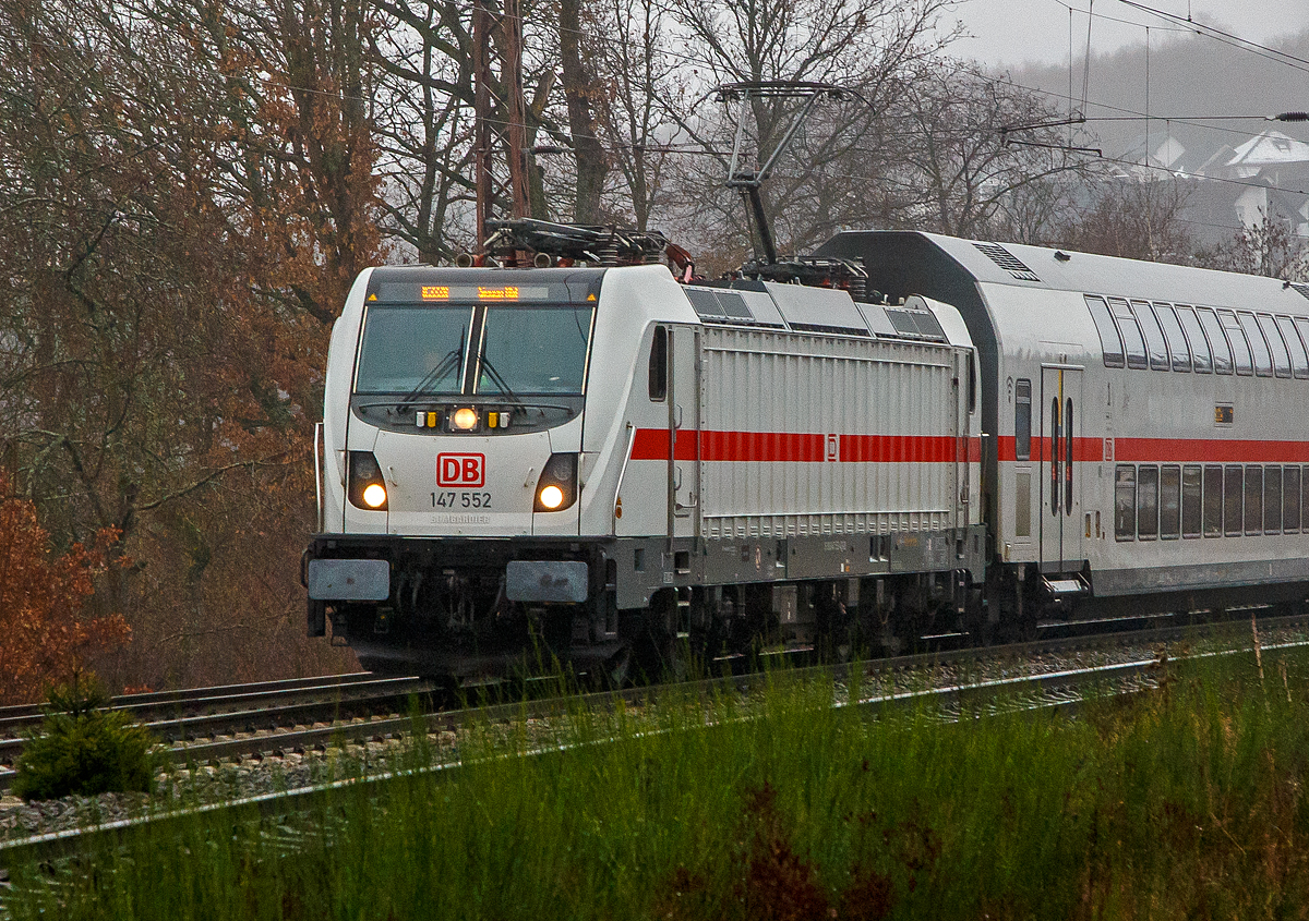 Eigentlich war heute kein Fotowetter, aber einen der ersten musste ich doch ablichten. 
Die 147 552 (91 80 6147 552-4 D-DB) der DB Fernverkehr AG fährt am 12.12.2021 mit dem IC2 (IC 2228) auf der Dillstrecke (KBS 445) durch Rudersdorf (Kr. Siegen) in Richtung Siegen. Zurzeit ist der Hbf Siegen Endstation, vermutlich ab 20.12.2012 ist es dann Hamm(Westf)Hbf.

Die TRAXX P160 AC3 wurde 2016 von Bombardier in Kassel unter der Fabriknummer 35224 gebaut und an die DB Fernverkehr AG geliefert. Sie hat die Zulassungen für Deutschland und die Schweiz, daher hat sie auch vier Stromabnehmer.

Die Deutsche Bahn hatte Mitte 2013 erstmals 20 Traxx P160 AC3 für DB Regio abgerufen. Die Maschinen (147 001–020) wurden nach rund zweijährigem Testlauf im Dezember 2016 nach Stuttgart ausgeliefert und absolvierten im Januar 2017 die ersten Einsätze. 

Im März 2015 rief die DB weitere 17 Traxx P160 AC3 ab, diesmal für die DB Fernverkehr AG, diese sollten mit zeitgleich nachbestellten Doppelstock-Intercity (IC2) eingesetzt werden, erhielten daher eine WTB-Steuerung. Angestrebt sind Zulassungen für Deutschland und die Schweiz, einschließlich ETCS-Level-2-Ausrüstung, zusätzlichen Stromabnehmern mit schmalen Paletten (1.450 mm), und seitlich angebrachten Videokameras als Rückspiegelersatz. Im Gegensatz zu den verkehrsroten Maschinen von DB Regio sind die als Baureihe 147.5 (551–567) bezeichneten Lokomotiven der  DB Fernverkehr in IC-Farbgebung (weiß mit verkehrsrotem Längsstreifen) lackiert, sie wurden bis Ende 2018 abgeliefert. Die Maschinen wurden mit Zielschildanzeigen über den Frontfenstern ausgerüstet.

TECHNISCHE DATEN:
Spurweite:  1.435 (Normalspur) 
Achsformel:  Bo’Bo’
Länge über Puffer:  18.900 mm 
Drehzapfenabstand: 10.440 mm
Höhe:  4.283 mm
Breite:  2.977 mm 
Treibraddurchmesser:  1.250 mm (neu) / 1.170 mm (abgenutzt)
Dienstgewicht:  87 t
Dauerleistung:  5.600 kW 
Höchstgeschwindigkeit:  160 km/h
Anfahrzugkraft:  300 kN
Stromsystem: 15 kV, 16,7 Hz ~ (25 kV, 50 Hz ~ möglich)
Bremse: bremsrechnergesteuerte elektrische Bremse, Druckluftbremse

Erstmals seit den TRAXX-Vorgängern AEG 12X respektive der Baureihe 101 von ABB Henschel wurde der Lokkasten nicht mit glatten Seitenwänden gefertigt. Konstruktiv deutlich günstiger, sind die Seitenwände der AC3 vertikal gesickt; stattdessen erhielten die Seitenflächen sogenanntem Flex-Panel, eine Vorrichtung zum Einspannen von Planen. Diese würden die Sicken verdecken, und wären kostengünstiger als Umlackierungen oder Umbeklebungen von Mietlokomotiven, zudem könnten die Halter auch Werbung anbringen.

Eine Variante „P189“ mit Hohlwellenantrieb und auf maximal 189 km/h gesteigerter Zulassung, wurde von Bombardier in Aussicht gestellt.
