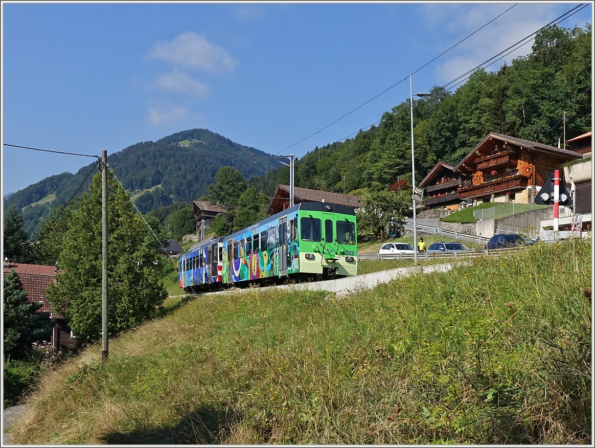 Ein bunter AOMC Regionalzug fährt von Aigle nach Champéry in Troistorrents vorbei.
(11.08.2015)
