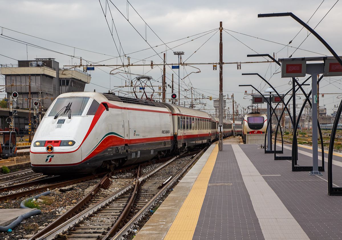 
Ein Frecciabianca (deutsch: weißer Pfeil) der Trenitalia fährt am 14.09.2017  in den Bahnhof Milano Centrale (Mailand Zentral) ein. 

Der Frecciabianca ist eine Zuggattung für Züge mit einer Höchstgeschwindigkeit von 200 km/h (IC), die nur im italienischen Gleichspannungsnetz verkehren. Oft werden sie als Triebzüge (ETR 500) bezeichnet...sind sie aber nicht, die Frecciabianca sind Lokbespannte Züge. Der Frecciabianca wird meist im Sandwich gefahren, das heißt eine E.414 vorne und eine weitere am anderen Ende, dazwischen vielen IC-Großraumwagen. Durch die IC-Wagen ist auch die Höchstgeschwindigkeit auf maximal 200 km/h beschränkt, die Loks könnten technisch 250 km/h fahren.

Die Loks wie hier die E.414 127-7 sind zwar ehemalige Triebköpfe der ersten Serie der ETR 500 (Monotensione = Ein-Spannung 3000 V DV) vom Typ 404 A, wurden aber ab 2007 zu E-Loks umgebaut. 