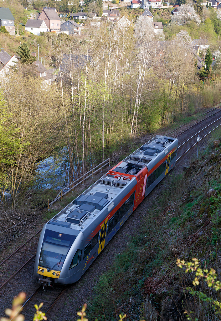 
Ein Stadler GTW 2/6 der Hellertalbahn als RB 96  Hellertalbahn  (Neunkirchen-Herdorf-Betzdorf/Sieg) hat am 24.04.2015 gerade den Hp Grünebach Ort verlassen und fährt nun weiter in Richtung Betzdorf.  

Neben dem noch aktiven Gleis der KBS 462 (Hellertalbahn), liegt hier noch das alte zweite Gleis, der einstigen zweigleisigen Hauptstrecke. Durch die Bäume hindurch noch zuerkennen, verläuft hier neben der Strecke die Heller. 
