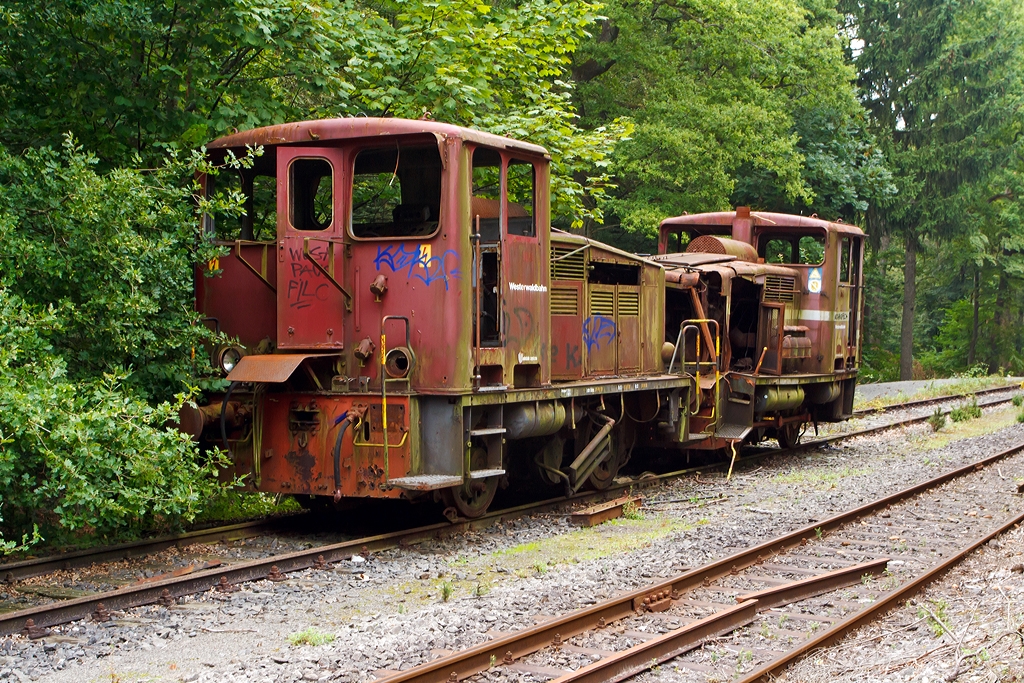 Ein trauriges Dasein friste diese Loks, sie dienen nur noch als Ersatzteilspender....

Die Westerwaldbahn (WEBA) Lok 2 und 4 (V 26.2 und V26.4) abgestellt (31.05.2013) etwas abseits des WEBE Betriebshofes auf der Bindweide (bei Steinebach/Sieg). 

Die Jung Loks vom Typ R 30 B wurden bei der Firma Jung in Kirchen/Sieg bebaut.
Hinten die V26.2 wurde 1956 unter der Fabriknummer 12103 gebaut, bei einem Unfall 1998 erlitt sie einen Totalschaden. Hinten die V26.4 wurde 1959 unter der Fabriknummer 12997 gebaut, diese wurde im selben Zeitraum als Ersatzteilspender angestellt.

Ihre Schwestern die V26.1 und V 26.3 laufen heute noch pr�chtig, zudem sind diese Maschinen sehr zuverl�ssig.