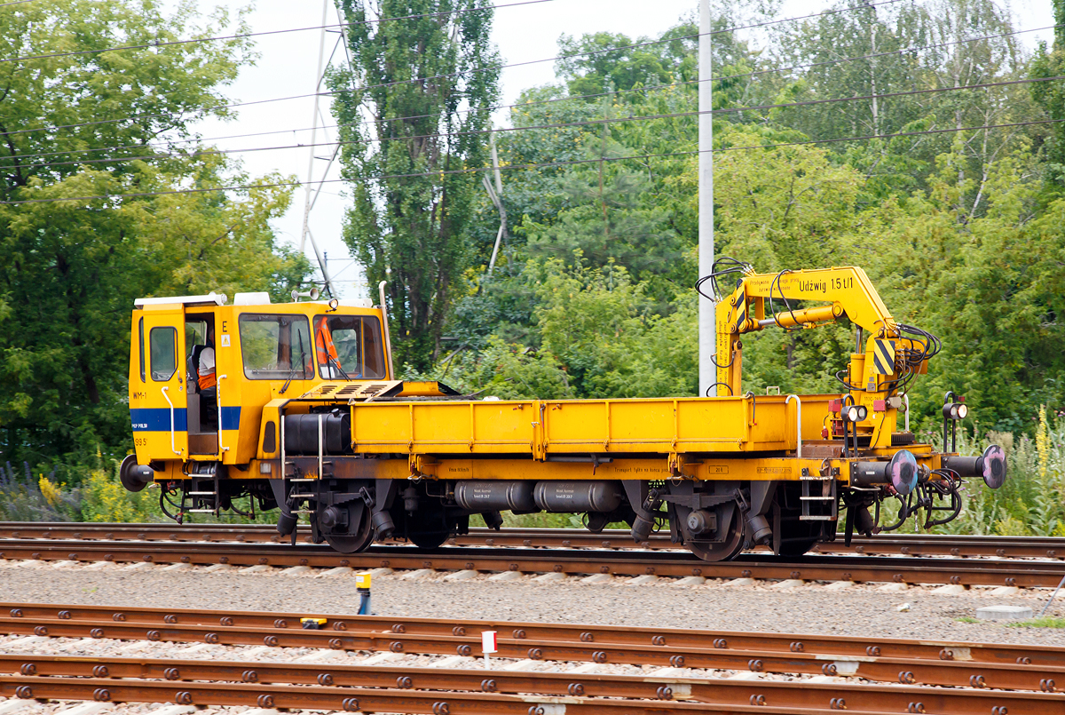 
Ein ZNTK Stargard WM-15  (9 483 076-7), ein Gleiskraftwagen der PKP Polskie Linie Kolejowe S.A. (PKP PLK) hat am 26.06.2017 gerade den Bahnhof Warszawa Gdańskain (in Warschau) durchfahren. 

Der WM-15A hat eine nach zwei Seiten kippbare Ladeplattform in der Abmessung 6.100 mm x 2.600 mm, mit  8 m� Fassungsverm�gen bzw. f�r 15 t Nutzlast. Er ist mit einem hydraulischen Kran mit einer Tragkraft von bis zu 1,5 t ausgestattet. 
Von den Fahrzeugen wurden zwischen 1977 bis 1998 von ZNTK Stargard (Zakłady Naprawcze Taboru Kolejowego in Stargard in Pommern) 555 Fahrzeuge gebaut. 

TECHNISCHE DATEN: 
Spurweite: 1.435 mm 
Anzahl der Achsen: 2 
L�nge �ber Puffer: 12 450 mm
Breite: 2. 800 mm
H�he: 3.360 mm
Achsabstand: 5.850 mm
Raddurchmesser (neu):  920 mm
Dienstgewicht : 20 t
Motor: WSK Mielec 6-Zylinder-Dieselmotor vom Typ SW680 / 123
Nennleistung: 147 kW (200 PS)
H�chstgeschwindigkeit:  80 km/h
Bremsanlage: Oerlikon