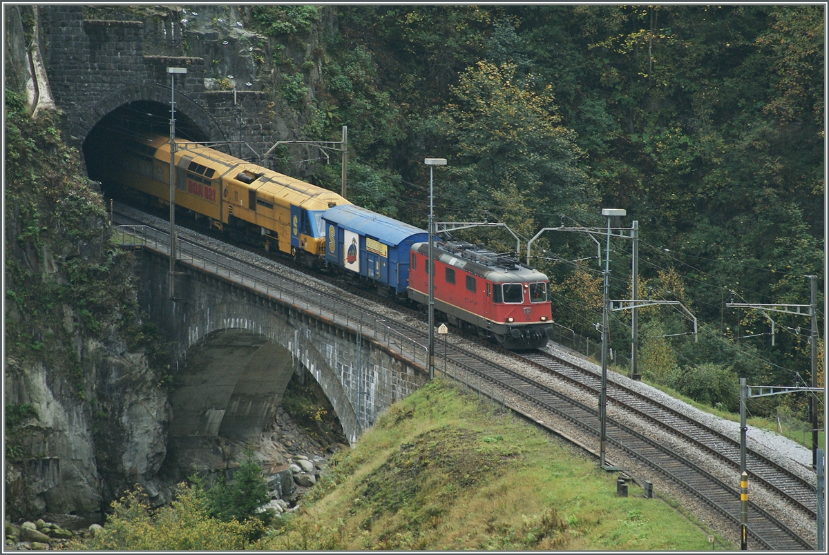 Eine Re 4/4 II mit  gelben Anhang  verlässt den Wattinger Kehertunnel bei Wassen.
10. Okt. 2014