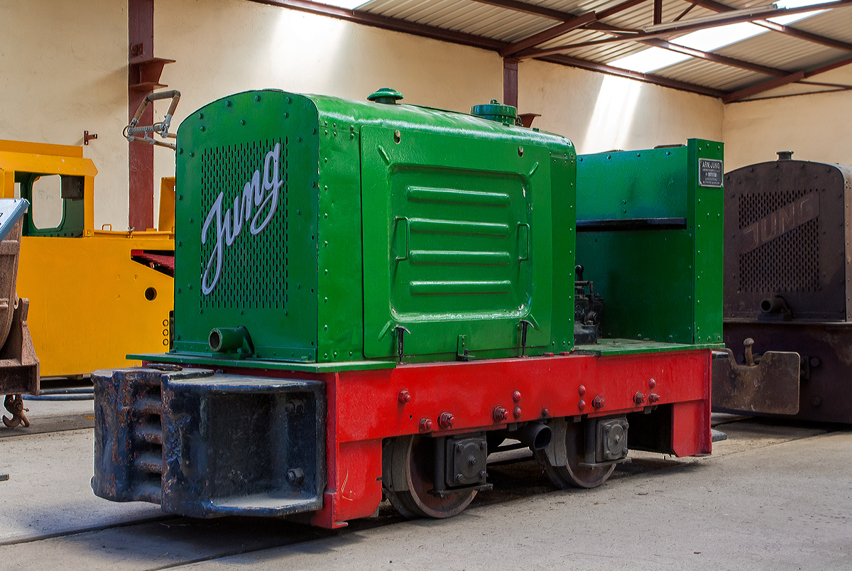 Feldbahn Diesellok Jung EL 110 (Baujahr 1936 unter Fabrik-Nr. 6610) im Feld- und Grubenbahnmuseum Fortuna (FGF Lok 53) am 07.07.2013 in Solms-Oberbiel. 

Die Firma Arnold Jung Lokomotiv-Fabrik GmbH aus Jungenthal bei Kirchen an der Sieg ist bekannt für eine außerordentlich vielfältige Lokomotivproduktion. In der über 100 jährigen Geschichte des Lokomotivbaues bei Jung nahmen Schmalspur-, Gruben- und Feldbahnlokomotiven stets einen wichtigen Platz ein. Seit den 1920er Jahren wurden in Jungenthal auch Feldbahn-Diesellokomotiven gefertigt. Der Loktyp EL 110 zählt zu dem Jung Diesellokprogramm der 2. Generation und wurde von 1934 bis 1963 in einer Stückzahl von ca. 900 Loks gefertigt. Die Lok ist mit dem Einzylinder Zweitaktmotor SE 110 (Stehender Einzylinder Zweitaktmotor mit einem Kolbendurchmesser von 110 mm, 11/12 PS) ausgerüstet. Über ein mechanisches Vierganggetriebe können Geschwindigkeiten von 3 bis 13 km/h erreicht werden.

Diese Feldbahnloktype war früher weit verbreitet. Von ihrer kleineren Schwester, der Type EL 105 unterscheidet sie sich hauptsächlich durch das mit Ganghebel zu schaltende Viergang-Getriebe. Die Lok wiegt 4 t, hat eine Leitung von 11-12 PS und eine Höchstgeschwindigkeit von 13 km/h.

Die Bezeichnung EL steht für Einzylinderlokomotive und die Zahl 110 weist auf den eingebauten Motor vom Typ SE 110 (110 mm Kolbendurchmesser) hin. Die S-Motortypenreihe stellt die zweite bei Jung entwickelte und gebaute Dieselmotoren-Generation dar. Die Motoren arbeiteten nach dem Zweitaktprinzip, sind wassergekühlt und besitzen Umlaufschmierung. Der Spüldruck wird im Kurbelgehäuse mittels Blattfeder-Einlaßventilen und Stufenkolben erzeugt. Als Direkteinspritzer sind die Motoren außerordentlich startfreudig und benötigen keine Lunte zum Ankurbeln. 

Die Lok hat zum Antrieb der Achsen nachspannbare Präzisons-Rollenketten. Die Klotzbremse wirkt über ein Hebelsystem ebenfalls auf beide Achsen. Ergonomisch vorteilhaft ist dabei, dass der Lokführer den Hebel zum Bremsen von sich wegdrücken muss und dafür guten Halt durch die Rückenlehne hat.

TECHNISCHE DATEN:
Hersteller: Arnold Jung Lokomotivfabrik GmbH, Jungenthal bei Kirchen an der Sieg
Typ:   EL 110
Fabriknummer: 6610
Baujahr: 1936
Spurweite: 600 mm
Achsfolge B
Dienstgewicht: 4,0 t
Leergewicht: 3,9 t
Länge über Puffer: 2.930 mm
Breite: 1.025 mm
Achsabstand: 780 mm  
Zugkraft: 775 kg (7,75 kN)
Fahrgeschwindigkeit:  3 - 5 - 8 - 13 km/h
Kleister Kurvenradius: 8,0 m
Bremse: Hand / mechanisch
Antrieb: Kette
Motor: Jung wassergekühlter stehender Einzylinder,2-Takt Dieselmotor mit Direkteinspritung vom Typ SE 110 (Fabriknummer 3085), Hubraum 1,8 l
Leistung: 11 / 12 PS bei 1000 U/min (Dauer- / Höchstleistung)
Getriebe: mechanisches Vierganggetriebe Jung Typ 12F (Fabriknummer 1051)
Anlasser: manuell mit Kurbel