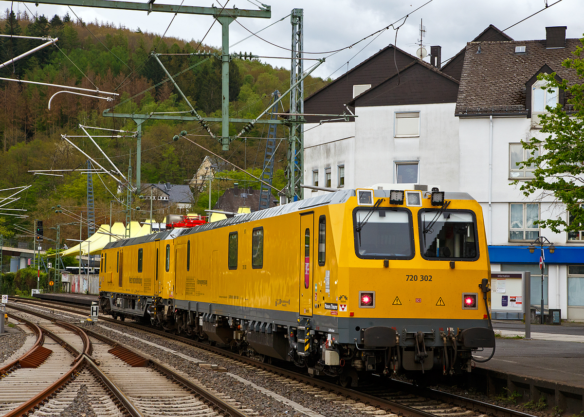 Glück für den Fotografen, das der Schienenprüfzug Hp 0 hatte....
Der Plasser & Theurer Schienenprüfzug (der Bauart SPZ 3) 719 302 / 720 302 (99 80 9160 005-1D-DB / 99 80 9360 008-3 D-DB) der DB Netz AG haete am 10.05.2021 im Bahnhof Betzdorf (Sieg) Hp 0, nun fährt er in Richtung Siegen weiter.

Der Schienenprüfzug wurde 2017 von Plasser & Theurer in Linz (A) unter der Fabriknummer 6048 (SPZ-STW) und  6049 (SPZ-ATW) gebaut.

Um Schäden am Oberbau frühzeitig zu erkennen, setzt die Deutsche Bahn AG verschiedene Prüfzüge der Baureihen 719 und 720 ein. Mittels zweier zerstörungsfreier Prüfverfahren werden die Schienen auf Schädigungen untersucht. Bei der Ultraschallprüfung können Materialfehler durch Materialermüdung innerhalb der Schiene bis zum Schienenfuß erkannt werden. Mit der Wirbelstromprüfung wird der Schienenkopf geprüft. 

Die Schienenprüfzüge der BR 719.3/720.3 wurden ab 2015  von Plasser & Theurer in Linz (A) gebaut. Diese dritte Messtriebwagengeneration entstand in modularisierter Bauweise. Sie basiert auf einer ein- und zweiteiligen Messwagenfamilie, die Ende 2012 von der DB bestellt wurde. Die Schienenprüfzüge sind zweiteilig ausgeführt und bestehen aus einem allachsgetriebenen Trieb- (ATW) und einem Steuerwagen (STW). Beide Wagen sind 23 Meter lang. Der ATW hat ein Eigengewicht von 81 t, der STW 67 t. Der Triebzug hat eine Höchstgeschwindigkeit von 140 km/h.
Unter dem Bodenrahmen des Steuerwagens sind zwischen den Drehgestellen ein absenkbarer Messwagen und zwei Wasserbehälter für die ZfP-Sensorik aufgehängt. Auf dem Dach des Triebwagens sitzt ein Messstromabnehmer. Als Antrieb dienen zwei Deutz-Dieselmotoren. Im hinteren Teil des Triebwagens gibt es eine klimatisierte Küche mit Mikrowelle, Herd, Spüle, Tisch und Sitzecke mit Wifi sowie eine Toilette. Im Steuerwagen sind neben dem Beobachtungsstand mit neun Monitoren eine Werkstatt mit Ersatzteillager und Kalibriergeräten, Schaltschränke mit Messtechnik, vier Schlafabteile und der Führerstand 1 untergebracht. Die Ultraschall- und Wirbelstrommesstechnik wurde von der Firma PLR Magdeburg geliefert. 
