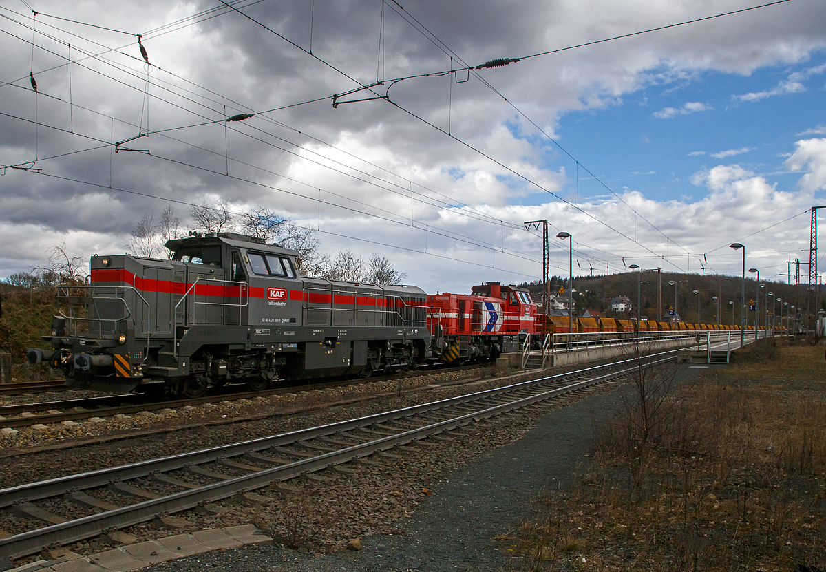 Im Doppelpack, ob man von einer Doppeltraktion sprechen ist mit nicht ganz klar, glaube aber nicht...
Die Vossloh G 12 – 4120 001-7 „Karl August“ (92 80 4120 001-7 D-KAF) und die Vossloh G 1000 BB - 271 022-6 „Charlotte“  (92 80 1271 022-6 D-KAF), ex HGK DH 49, beide von der KAF Falkenhahn Bau AG (Kreuztal) fahren am 11.03.2021, mit einem sehr langen Güterzug durch Rudersdorf (Kreis Siegen) in nördlicher Richtung, vermutlich Richtung Heimat Bf Kreuztal. Im Zugverband waren vorne einige mit Kies beladene KAF Kippwagen MK 45 DH „LW-Kipper“ der Gattung Rlps, dann etliche leere 2-achsiger Flachwagen für Schotter und Sand der Gattung NS Klmos 702 von Railpro und am Zugende noch vier 2-achsige Schüttgutwagen für Schotter der Gattung NS Fccpps von Railpro.

Von der Vossloh G 12 – 4120 001-7 „Karl August“ sind hier schon Daten und der Lebenslauf vorhanden, daher nur den Lebenslauf der Vossloh G 1000 BB - 271 022-6 „Charlotte“:
Die G 1000 BB wurde 2005 von Vossloh in Kiel unter der Fabriknummer 5001568 gebaut. Im Jahr 2006 wurde sie an die MRCE - Mitsui Rail Capital Europe B.V. verkauft, die die Lok an die HGK - Häfen und Güterverkehr Köln AG in Köln (HGK DH 49) vermietete, wo sie bis unter der NVR-Nummer 92 80 1271 022-6 D-DISPO fuhr. Danach hatte sie bis zum Verkauf im Jahr 2017 an die northrail GmbH in Hamburg, mehrere Mietstation. Von 2017 fuhr sie unter der NVR-Nummer 92 80 1271 022-6 D-NRAIL bis sie 2020 an die Michael Bugdoll Bau- und Sicherungsarbeiten e. K. in Dorsten ging und als 92 80 1271 022-6 D-MBBAU fuhr. 

Zum 01.01.2021 wurde sie an die KAF Falkenhahn Bau AG in Kreuztal verkauft und hört nun auf den Namen „Charlotte“ (92 80 1271 022-6 D-KAF).