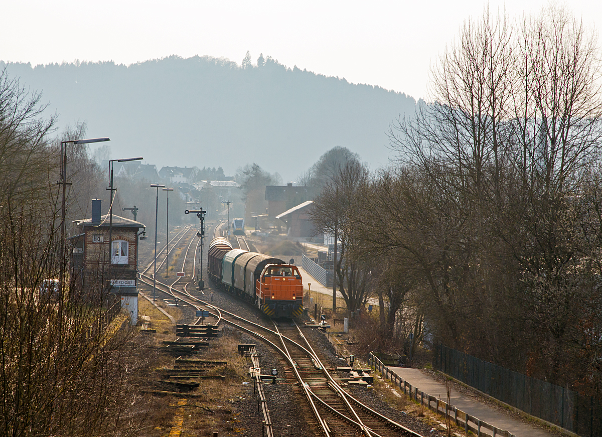 
Im Gegenlicht....
Die Lok 44 ( 92 80 1 271 004-4 D-KSW) der KSW (Kreisbahn Siegen-Wittgenstein), eine MaK G 1000 BB, kommt mit einem Coil-Güterzug am 16.03.2015 aus Betzdorf über KBS 462 (Hellertalbahn) in Herdorf an. 
Hinten am Bahnhof hält gerade ein GTW 2/6 der Hellertalbahn weiter in Richtung Betzdorf.