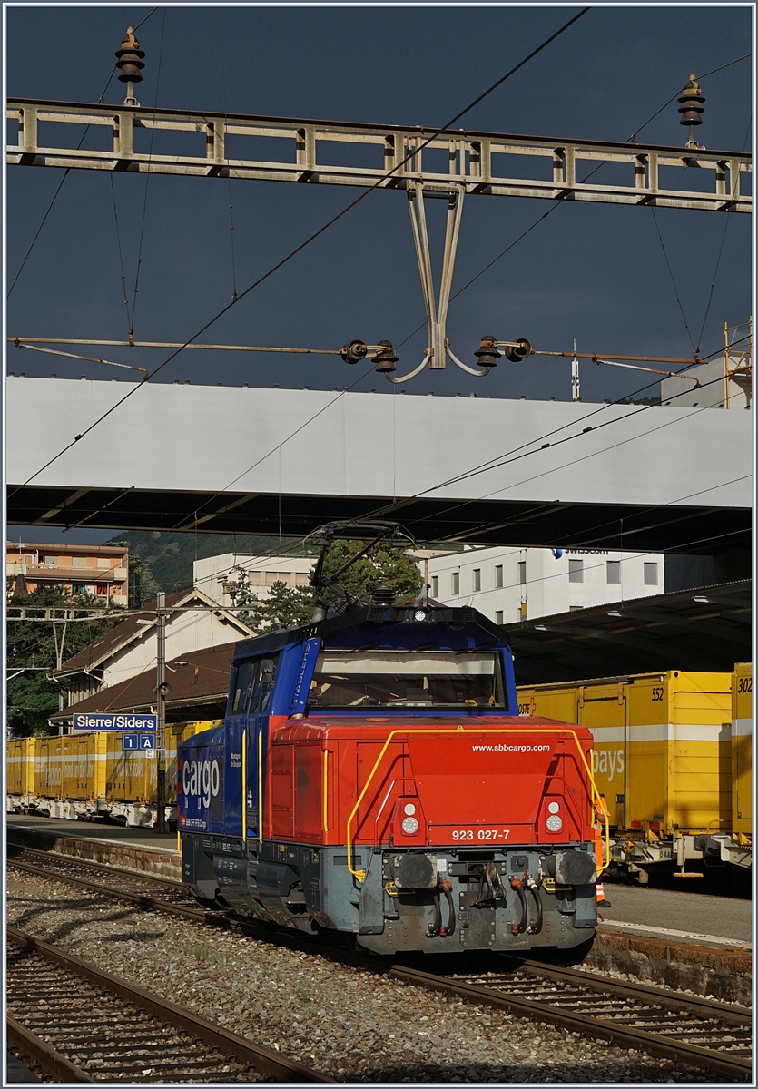 In Sierre, vor einem ziemlich dunklen Himmel zeigt sich die SBB Cargo Eem 923 027-7 im Sonnenlicht.
31. Juli 2017