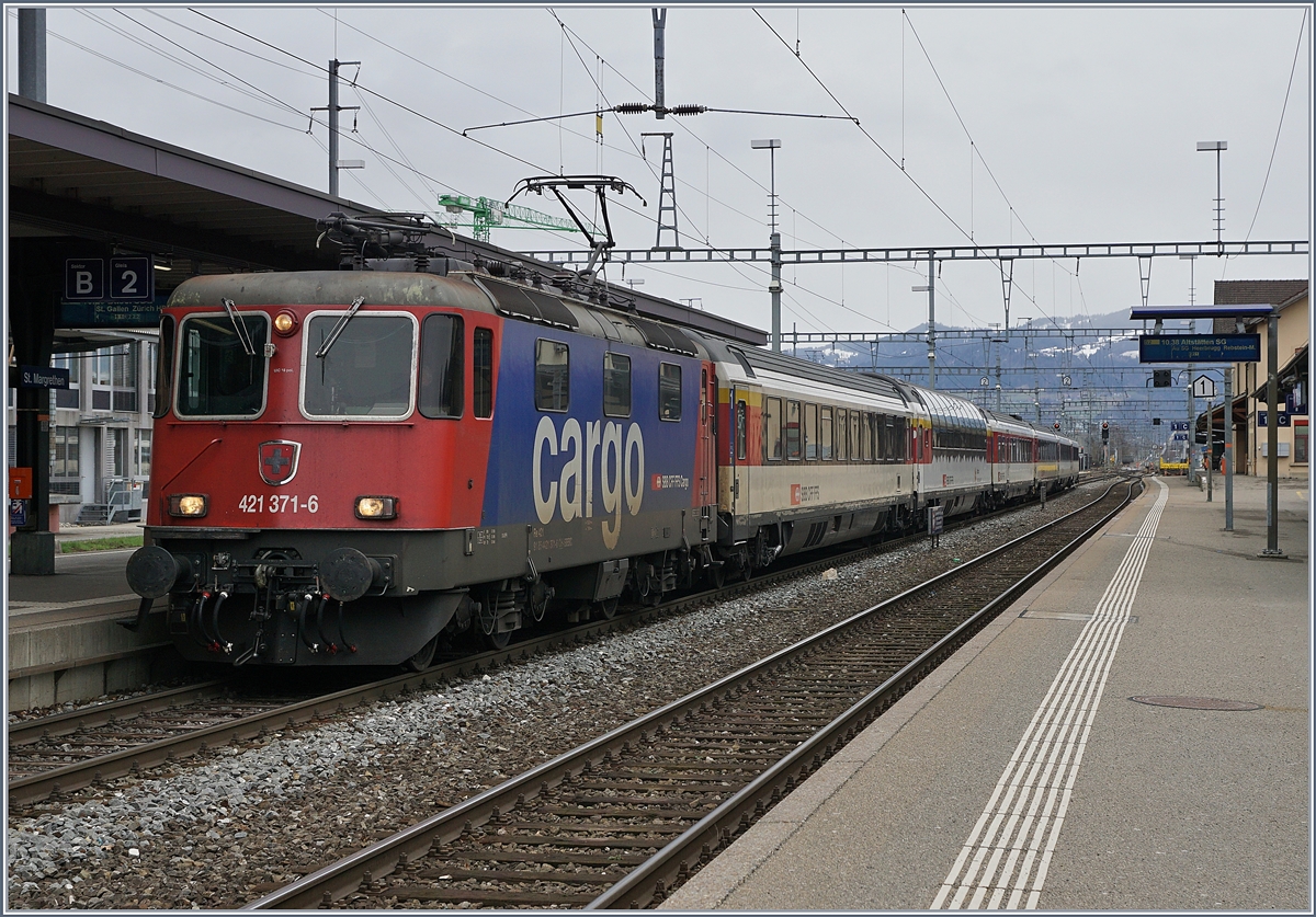 Mit dem breiten Stromabnehmer an der Fahrleitung trifft die SBB Re 421 371-6 mit ihrem in Lindau übernommen EC nach Zürich in St.Margrethen ein. 

14. März 2019