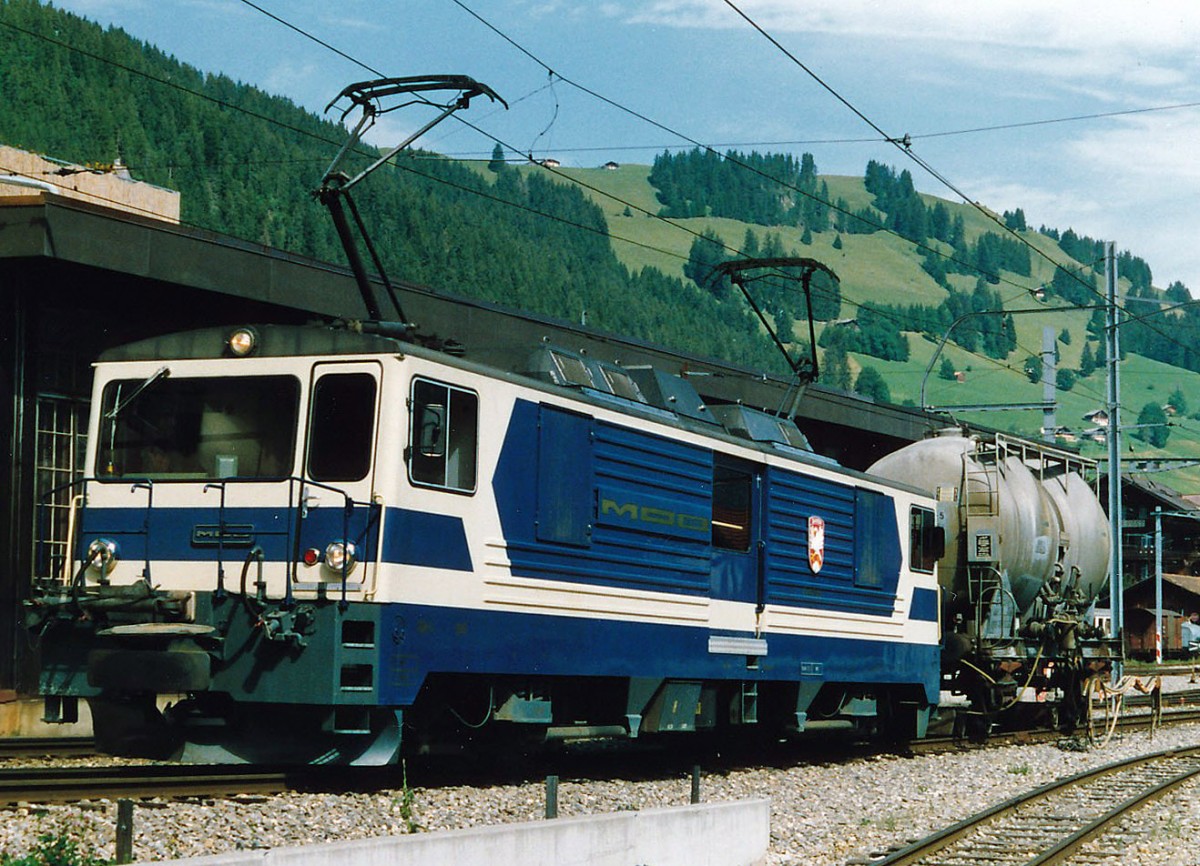 MOB: W�hrend den vielen Jahren, da ich die MOB fotografierte, erlebte ich nie einen eihheitlichen Farbanstrich. Bereits die im Jahre 1983 in den Betrieb gestellten GDe 4/4 6001 bis G004 wurden in einem eher dunkelblauen Farbkleid abgeliefert. Bald aber ist die urspr�ngliche einheitliche Farbgebung durch die verschiedesten Werbeaufschriften verdr�ngt worden. GDe 4/4 6002 im Ablieferungszustand mit einem Rollbockzug in Zweisimmen im Jahre 1984.
Foto: Walter Ruetsch    