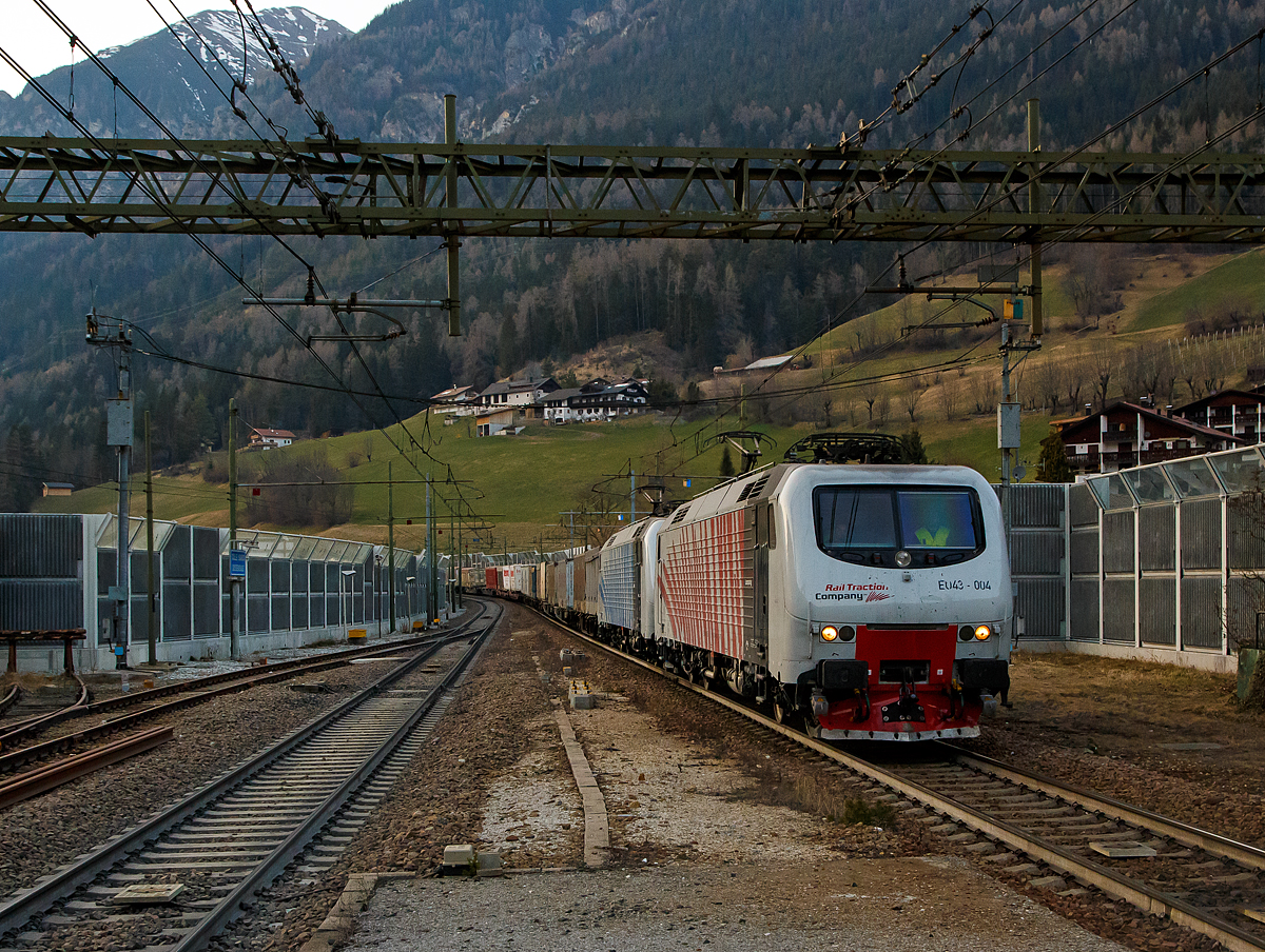 Noch ist Winterzeit, daher etwas dunkel....
In Doppeltraktion fahren die beiden Rail Traction Company (RTC) EU43 – 004 (91 83 2043 004-7 I-RTC) und die EU43 – 008 (91 83 2043 008-8 I-RTC), vom Brenner kommend am 26.03.2022 mit einem KLV-Zug durch den Bahnhof Gossensa�/Colle Isarco in Richtung Verona. Nochmal einen lieben Gru� an den netten Lokf�hrer zur�ck, der mich mit Dreilicht gr��te. 

Die Loks wurden 2001 bzw. 2002 von Bombardier unter den Fabriknummer 112E 06, 112E 04 bzw. 112E 03 gebaut und waren eigentlich f�r die Lieferung (8 St�ck) an die polnische PKP - Polskie Koleje Państwowe vorgesehen, der Verkauf scheitere aus finanziellen Gr�nden seitens der PKP. Die 8 polnischen Loks sind danach an die italienische Privatbahngesellschaft RTC (Rail Traction Company) verkauft worden, die polnische Bezeichnung EU43 wurde sp�ter an Lokomotiven der TRAXX-Variante MS2 vergeben.

Die Loks der Baureihe EU43 vom Typ Bombardier 112E sind �hnlich denen der ab 1996 vom damaligen Hersteller ABB Tecnomasio in Vado Ligure (Italien) gebauten 20 Brennerloks der FS Baureihe E.412 (Adtranz 112E). Die E.412 haben z.B. das F�hrerpult wie in Italien �blich links und nicht wie die f�r Polen vorgesehenen EU43 rechts, daher sind beide in Italien als unterschiedlichen Baureihen eingeordnet.

Auch wenn die Lok nur zwei Stromabnehmer der Bauart WBL 85 haben, sind es elektrische Mehrsystemlokomotiven f�r 15 kV, 16,7 Hz Wechselstrom und 3 kV bzw. 1,5 kV Gleichstrom. Jeeils ein Stromabnehmer ist f�r Gleichspannung (F�hrerstand A, italienische Palette) und einer f�r Wechselspannung (F�hrerstand B, deutsch-�sterreichische Palette). Die Lokomotiven verf�gt �ber eine elektrische Nutzbremse. 

Urspr�nglich war f�r beide Baureihen die Zulassung f�r �sterreich und Deutschland vorgesehen. Die �BB hatte zun�chst die Zulassung verweigert und erst 2006 erteilt.

Geschichte:
Im Jahr 1993 gaben die FS im Zuge der wachsenden internationalen Aktivit�ten der europ�ischen Bahngesellschaften Mehrsystemlokomotiven in Auftrag, die sowohl im italienischen 3-kV-Gleichstromnetz als auch im S�den von Frankreich (1,5 kV =) und insbesondere f�r den Brennerverkehr auch im �sterreichischen und deutschen Netz (15 kV, 16,7 Hz) einsetzbar sein sollte. Die Lokomotiven sollten sowohl f�r schnelle EuroCity-Z�ge als auch f�r den G�terverkehr einsetzbar sein. Die vier Prototyp-Lokomotiven wurden ab 1996 vom damaligen Hersteller ABB Tecnomasio (heute Alstom) in Vado Ligure, Italien, gebaut. Dieses Werk produziert nahezu ausschlie�lich f�r den italienischen Markt. 

Technik:
Die Lokomotiven laufen auf Drehgestellen mit Integriertem Gesamtantrieb (IGA), der auch bei den Lokomotiven der DB-Baureihe 101 und den italienischen E405 vorhanden ist, die Stromrichter �hneln denen der SBB Re 460. F�r den Antrieb werden Doppelsternmotoren verwendet, was Drehstrom-Asynchronmotoren mit zwei Wicklungssystemen in Sternschaltung im selben Geh�use sind – eine eher un�bliche Schaltung.

Der geschwei�te Wagenkasten in Stahlleichtbaukonstruktion st�tzt sich �ber Flexicoil-Schraubenfedern auf die Drehgestelle ab. Die Seitenw�nde aus Aluminium sind zur Erh�hung der Steifigkeit gesickt. Der estergek�hlte Transformator ist wie bei Neubaulokomotiven �blich unterflur angeordnet. Die Lokomotive ist mit Gruppenantrieb ausgef�hrt, wobei eine Antriebsgruppe aus einer Achse aus dem Drehgestell 1 und einer aus dem Drehgestell 2 besteht, eine ebenfalls un�bliche Anordnung.

Die Lokomotiven verf�gt �ber eine elektrische Nutzbremse. Es sind zwei Einholmstromabnehmer der Bauart WBL 85 vorhanden, je einer f�r Gleichspannung (F�hrerstand A, italienische Palette) und Wechselspannung (F�hrerstand B, deutsch-�sterreichische Palette).

In der Lokomotive sind zwei Stromrichter angeordnet. Unter Wechselstromsystemen wird die sekund�rseitige Spannung des Haupttransformators in einem Vierquadrantensteller (4QS) in eine Gleichspannung umgewandelt, welche in einen Gleichstromzwischenkreis eingespeist wird. Unter den Gleichstromsystemen erfolgt die Speisung des Zwischenkreises direkt aus der Fahrleitung.

Die Pulswechselrichter wandeln den Gleichstrom des Zwischenkreises in Dreiphasenwechselstrom zur Speisung der Fahrmotoren um. Im Gleichstromnetz sind zwei Pulswechselrichter in Serie geschaltet, die je ein Wicklungssystem der Fahrmotoren mit Strom versorgen, im Wechselstromsystem wird nur ein Pulswechselrichter ben�tigt, der die beiden parallel geschalteten Wicklungssysteme der Fahrmotoren mit Spannung versorgt.

Die Steuerung der Antriebe erfolgt durch ein rechnerunterst�tztes Betriebssystem. Die Lokomotiven sind mit 18-poligen IS-Steckdosen f�r die UIC-Leitung, einer Vielfachsteuerung und einer Speiseeinrichtung der Zugsammelschiene f�r Reisez�ge ausger�stet. Lauftechnisch sind die Lokomotiven f�r eine Geschwindigkeit von 220 km/h ausgelegt, jedoch in Italien nur f�r 200 km/h zugelassen. Ausger�stet wurden sie mit Fahrzeugeinrichtungen der Zugbeeinflussungen RS4 Codici (Italien) sowie punkt- und linienf�rmiger Zugbeeinflussung (�sterreich und Deutschland). Von einem Einsatz in Frankreich wurde abgesehen.

TECHNISCHE DATEN:
Spurweite: 1.435 mm (Normalspur)
Achsformel: Bo'Bo'
L�nge: 19.400 mm
Drehzapfenabstand: 11.400mm
Achsabstand im Drehgestell: 2.650 mm
Dienstgewicht: 88 t
H�chstgeschwindigkeit: 140 km/h Italien und Deutschland / 120 km/h �sterreich
Dauerleistung: 5.600 kW (15 kV AC) / 5.400 kW (3 kV DC) / 2.700 kW (1,5 kV DC)
Anfahrzugkraft: 300 kN
Stromsysteme: 15 kV, 16,7 Hz AC, 3.000 V DC und 1.500 V DC 
Anzahl der Fahrmotoren:  4� IGA-Drehstrom-Asynchronmotoren, Typ FIA 7065
Kleister befahrbarer Gleisbogen: R 95 m
Bremse: Druckluftbremse, el. Nutzbremse
Zugbeeinflussung: RS 4 Codici, PZB, LZB
