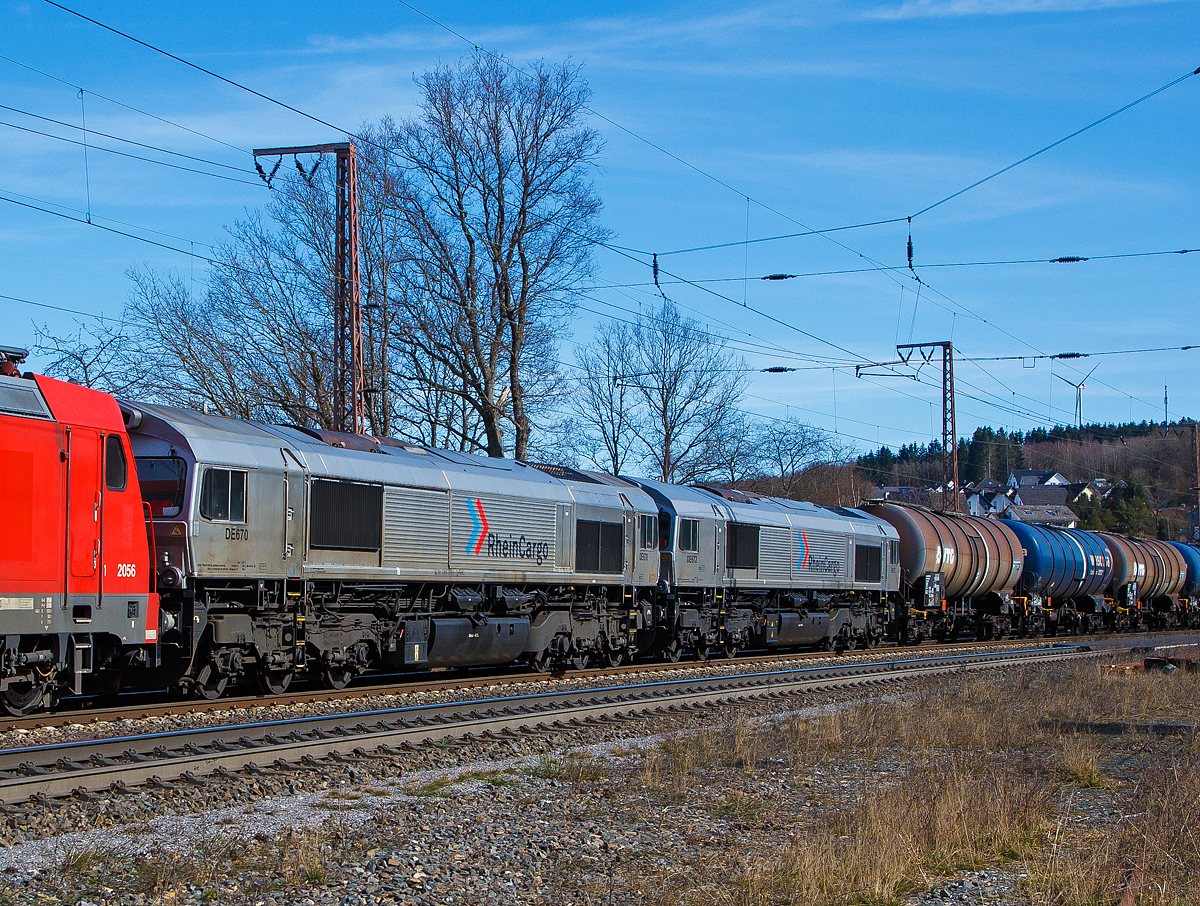 Nochmals im Detail...
Die beiden Class 66 (EMD JT42CWR) RheinCargo DE 670 (92 80 1266 070-2 D-RHC) und die DE 672 (92 80 1266 072-8 D-RHC) geschleppt von der RHC 2056 bzw. 185 588-1 (91 80 6185 588-1 D-RHC, die am 20.03.2021mit den beiden Class 66 und einem Kesselwagenzug, durch Rudersdorf (Kr. Siegen) über die Dillstrecke (KBS 445) in nördlicher Richtung fährt.

Lebensläufe der Loks:
Die beiden EMD JT42CWR (auch bekannt als Class 66) wurde 2003 von EMD (Electro-Motive Division eine Tochter von General Motors) gebaut, die RHC DE 670 (92 80 1266 070-2 D-RHC), ex HGK DE 170, unter der Fabriknummer 20028453-3 und die DE 672 (92 80 1266 072-8 D-RHC), ex HGK DE 172, unter der Fabriknummer 20028453-5. Eigentümer und Vermieter der beiden Class 66 ist die Beacon Rail Leasing Ltd in London, bis zum Verkauf zum 01.01.2007 war  es die HSBC Rail Ltd., London.