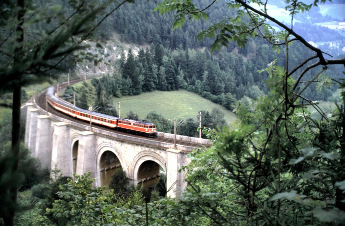 ÖBB 1042 mit Personenzug am Semmmering auf dem Unterer-Adlitzgraben-Viadukt am 09.08.1986.