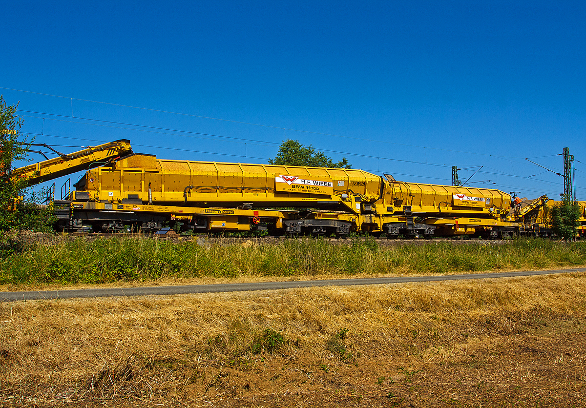 Plasser & Theurer Materialf�rder- und Siloeinheit MFS 250 (H.F. Wiebe Bezeichnung Bunker-Sch�ttgut-Wagen BSW 11000), Schweres Nebenfahrzeug-Nr.99 80 9552 063-6 D-GBM (ex 97 19 17 503 57-7), EBA-Nr.  EBA 02 C 02B002, der GBM Wiebe Gleisbaumaschinen GmbH, am 20.07.2013 in Katzenfurt  (Lahn-Dill-Kreis) an der KBS 445  Dillstrecke .

Die MFS 250 wurde bei Plasser & Theurer 2004 unter der Fabriknummer 4327 gebaut.

Die Material-F�rder- und Siloeinheit MFS 250 dient zum Transport von Schotter oder des Abraums im Rahmen der Schotterbettreinigung oder Untergrundsanierung. Eine Aufnahmekapazit�t von 110 m� pro MFS 250-Einheit und eine F�rderleistung von bis zu 1.000 m�/h kommen den hohen Materialmengen, die bei diesen Arbeiten anfallen, entgegen. Hauptvorteil des MFS 250 ist, wie schon bei den anderen bew�hrten Modellen der MFS-Serie, der kontinuierliche F�rder-, Speicher- und Entladevorgang.

Der MFS 250 ist als offener Bordwagen in Gelenkbauweise mit vier dreiachsigen Drehgestellen gestaltet und in Regelfahrzeugbauart ausgef�hrt. Die beiden mittleren Drehgestelle sind mit einem Rahmen verbunden auf dem sich �ber ein Gelenk der vordere und hintere Siloteil des MFS 250 abst�tzt. Die F�rderb�nder werden hydraulisch angetrieben, die Energie dazu liefert ein Dieselmotor der sich unterhalb des hinteren Fahrzeugrahmens befindet.


Der Boden des MFS 250 besteht aus zwei 1.920 mm breiten F�rderb�ndern. Die hintere Stirnseite des Silos ist geschlossen. Am vorderen Ende des Wagens ist ein nach links oder rechts schwenkbares F�rderband angeordnet, welches zum Entladen bzw. zur Weitergabe des Transportgutes dient.

Das Entladeband ist nach beiden Seiten ausschwenkbar. Dadurch kann das Material auf bereitgestellte Bahnwagen, Beh�ltertransportwagen, LKW oder auf Halden gef�rdert werden. S�mtliche Einheiten des Abraumzuges k�nnen bei ausschlie�licher Verwendung von MFS 250 durch Ausschwenken der Entladeb�nder gleichzeitig entleert werden. Eine Sicherheitseinrichtung erkennt rechtzeitig ein m�gliches Kippen des Fahrzeugs, schaltet das F�rderband ab und schwenkt es ein. 

ARBEITSWEISE:
Die Bunker-Sch�ttgut-Wagen k�nnen unter spannungsf�hrender Fahrleitung eingesetzt werden.
Die BSW-11000 k�nnen mit MFS-38, MFS-40, MFS-100, BSW-2000 und BSW-6000 gekoppelt werden.

Der Boden des BSW ist als steuerbares Speicherbodenband mit einer F�rderbreite von 1.920 mm ausgebildet. An einem Wagenende ist ein �bergabeband mit ebenfalls 1.920 mm F�rderbreite angeordnet, in der Ausf�hrung als Durchf�rderwagen nicht seitlich schwenkbar, als Entladewagen beidseitig 45 Grad schwenkbar mit einer maximalen Ausschwenkweite von 4.400 mm ab Gleismitte. 

Mit diesen Schwenkb�ndern k�nnen Flachwagen im Nachbargleis bis 4,5 m Gleisabstand mittig beladen werden.
Die BSW k�nnen als Silowagen mit 110 m� oder 140 t bei Streckenklassen D4, oder als Durchf�rderwagen 800 m�/h verwendet werden.

Die F�rderb�nder sind in folgenden Geschwindigkeiten stufenlos regelbar:
Siloband: 1. Gang (Speichern) 0 - 0,028 m/s / 2. Gang (Durchf�rdern) 0 - 0,140 m/s
�bergabeband: 0 - 1,000 m/s
Die Abwurfh�he betr�gt max. 3.950 mm �ber SOK.


TECHNISCHE DATEN:
Spurweite:  1.435 mm
Anzahl der Achsen: 12 (in 4 Drehgestellen)
L�nge �ber Puffer: 38.000 mm
Drehzapfenabstand:  11.700 / 8.000 / 11.700 mm
Achsabst�nde in den Drehgestellen: jeweils 2 x 1.800 mm
Laufraddurchmesser: 850 mm (neu)
Siloinhalt:  110 m�
F�rderleistung max.: 800 - 1000 m�/h (materialabh�ngig)  
Entladezeit: ca.  7 min.
Kraftversorgung:  wassergek�hlter 6-Zylinder Deutz-Dieselmotor mit Ladeluftk�hlung, Typ BF 6M 1013 C 
Hubraum: 7,14 l
Motorleistung:  170 kW bei 2.300 U/min
Kleinster fahrbarer Radius:  120 m
L�nge inkl. F�rderband, ca.:  41.700 mm
Breite (max. bei �berstellfahrt)  3.100 mm
H�he �ber SOK  4.190 mm
Eigengewicht, ca.: 114,6 t
Max. Ladegewicht: 136 t (Streckenklasse CE und D4)
Max. Gesamtgewicht bei �berstellfahrt f�r Streckenklasse CE und D4:  252 t
Max. Geschwindigkeit gezogen: 100 km/h 

