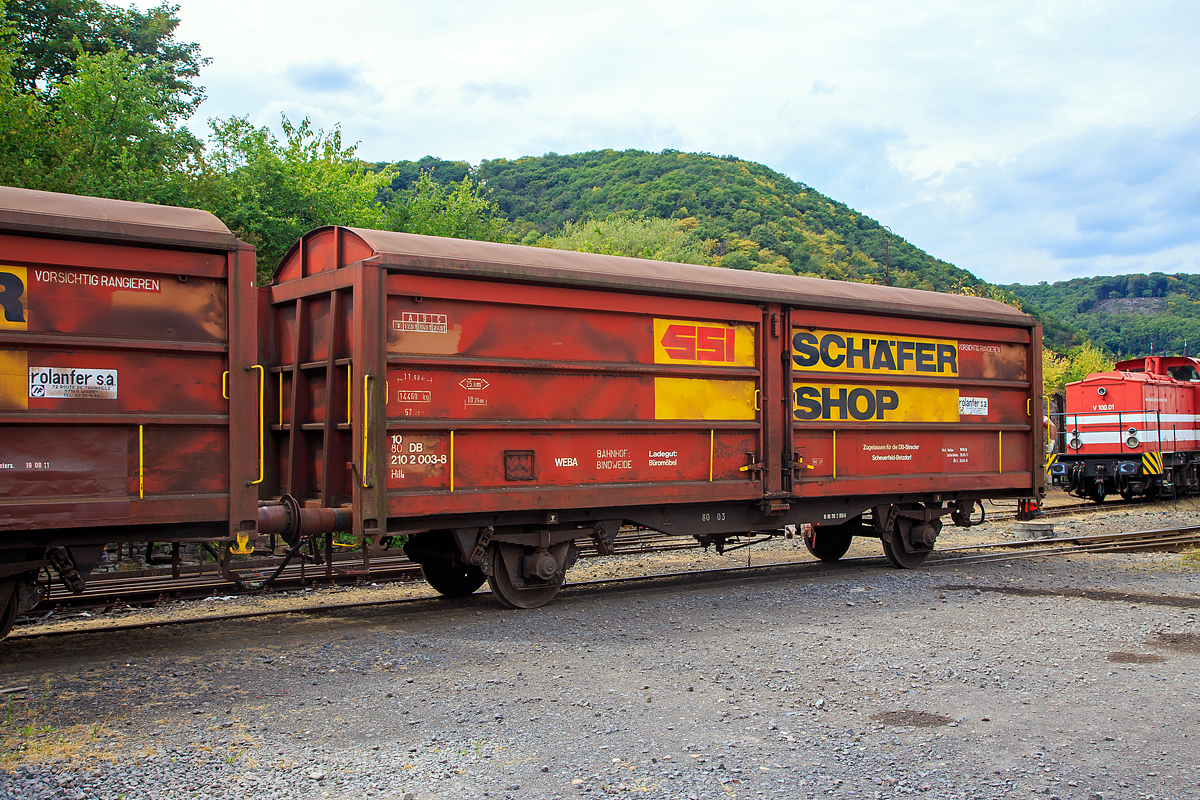 Privater gedeckter G�terwagen mit Schiebew�nden der Gattung Hills, 10 80 2102 003-8, WEBA 04  (10 80 DB 210 2 003-8), der Westerwaldbahn (WEBA) am 03.08.2020 im Zugverband in Brohl-L�tzing auf der Gleisanlage Rheinanlage der Brohltal Eisenbahn (BEG). Es fand eine praktische Ausbildung von Rangierbegleitern stand. 

Der Wagen wurde 1989 von Rolanfer Mat�riel Ferroviaire SAS in Metz-Woippy (Frankreich) unter der Fabriknummer 534013 f�r die SNCB gebaut, wann er auf den Westerwald kam ist mir unbekannt.

Beschreibung:
Der Wagen hat auf jeder L�ngsseite zwei Schiebew�nde, so ist es m�glich jeweils eine halbe L�ngsseide zu �ffnen. Eingesetzt wurden diese Waggons f�r den Transport von gro�en n�sseempfindlichen St�ckg�tern (bei dem Wagen waren es B�rom�bel).

TECHNISCHE DATEN:
Spurweite: 1.435 mm
L�nge �ber Puffer :11.690 mm
Achsabstand: 8.000 mm
Eigengewicht: 14.460 kg
Ladel�nge:10.260 mm
Ladefl�che: 25,8 m�
Rauminhalt: 57,41 m�
H�chstgeschwindigkeit:  100  km/h 
Maximales Ladegewicht: 20,5 t (Streckenklasse C oder h�her)
Bremse: KE-GP 

Bei der WEBA war der Wagen nur auf der DB Strecke Scheuerfeld (Sieg) – Betzdorf (Sieg) zugelassen. Die WEBA hat 2017 den G�terverkehr eingestellt. Zudem ist f�r den Kunden der Bahntransport von B�rom�bel (von Weitefeld nach Betzdorf) nicht mehr n�tig. Ob der Wagen noch der WEBA ist und verliehen wurde oder ob er von BEG �bernommen wurde, ist mir nicht bekannt.