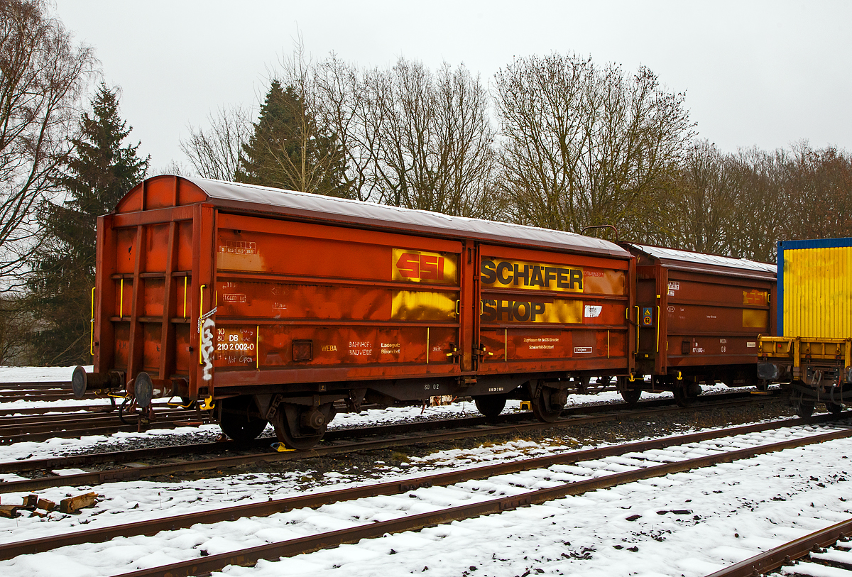 Privater gedeckter Güterwagen mit Schiebewänden der Gattung Hills, 10 80 2102 002-0, WEBA 03  (10 80 DB 210 2 002-0), der Westerwaldbahn (WEBA) abgestellt am 11.12.2021 auf dem Betriebshof der WEBA)auf der Bindweide bei Steinebach/Sieg abgestellt.

Der Wagen wurde 1989 von Rolanfer Matériel Ferroviaire SAS in Metz-Woippy (Frankreich) unter der Fabriknummer 534012 für die SNCB gebaut, wann er auf den Westerwald kam ist mir unbekannt.

Beschreibung:
Der Wagen hat auf jeder Längsseite vier Schiebewände, so ist es möglich jeweils eine halbe Längsseide zu öffnen. Eingesetzt wurden diese Waggons für den Transport von großen nässeempfindlichen Stückgütern (bei diesem Wagen waren es Büromöbel).

TECHNISCHE DATEN:
Spurweite: 1.435 mm
Länge über Puffer :11.690 mm
Achsabstand:  6.000 mm
Eigengewicht: 14.460 kg
Ladelänge:10.260 mm
Ladefläche: 25,8 m²
Rauminhalt: 57,41 m³
Höchstgeschwindigkeit:  100  km/h 
Maximales Ladegewicht: 20,5 t (Streckenklasse C oder höher)
Bremse: WE-GP 

Bei der WEBA war der Wagen auf der eigenen Strecke (Scheuerfeld – Bindweide – Weitefeld) und nur auf der DB Strecke Scheuerfeld (Sieg) – Betzdorf (Sieg) zugelassen. Die WEBA hat 2017 den Güterverkehr eingestellt. Zudem ist für den Kunden der Bahntransport von Büromöbel (von Weitefeld nach Betzdorf) nicht mehr nötig.
