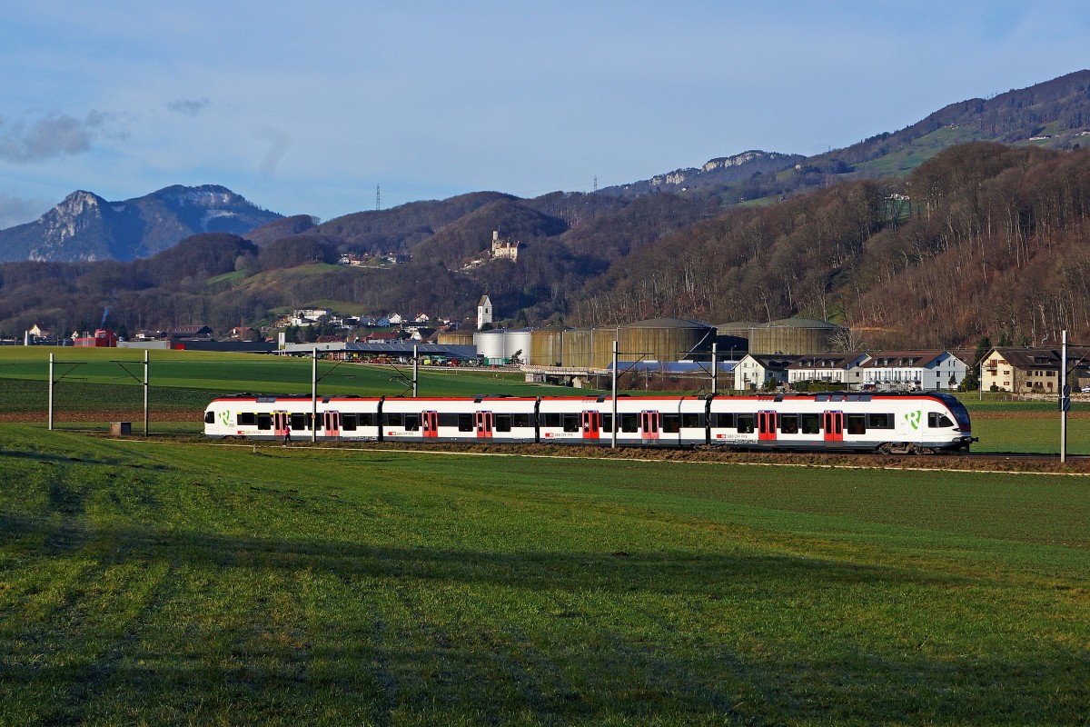 SBB: Morgendliche Winterstimmung vom 21. Dezember 2014 bei Niederbipp. Nur drei Tage vor Weihnachten fehlt noch immer die weisse Pracht. Regionalzug Biel-Olten mit  FLIRT  bei Niederbipp unterwegs vor der Kulisse der ersten Jurakette mit Schloss Bipp und der Evangelisch reformierten Kirche Oberbipp.
Foto: Walter Ruetsch