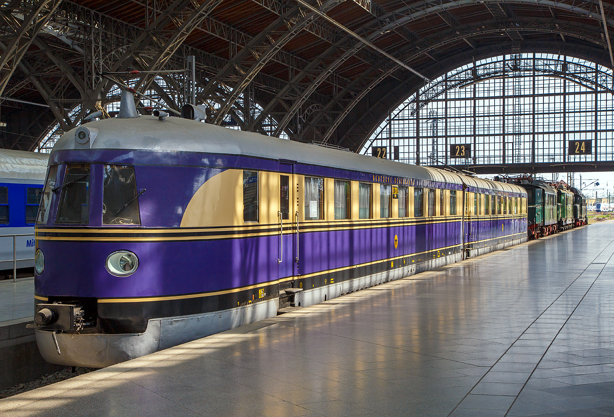 
Schon in den 1930er-Jahren fuhr man mit 160 km/h über die Gleise....

Der SVT 137 225 a/b ex DR 183 252, ausgestellt im Leipziger Hauptbahnhof auf dem Museumsgleis bzw. Traditionsgleis den Gleis 24, hier am 21.05.2016. Bei der Deutschen Bundesbahn wurden diese Schnelltriebwagen als Baureihe VT 04 bezeichnet.

Das Fahrzeug, der Schnelltriebwagen SVT 137 225, wurde Anfang 1934 von der Deutschen Reichsbahn Gesellschaft bei der WUMAG (Waggon- und Maschinenbau Aktiengesellschaft Görlitz), Abt. Waggonbau bestellt. Der SVT wurde am 04. Juli 1935 geliefert und am 08. August 1935 im RAW Wittenberge abgenommen und in Dienst gestellt. 

Das Fahrzeug entstand aufgrund der sehr  guten Erfahrungen mit dem als „Fliegender Hamburger“ berühmt gewordenen VT 877 (Prototyp). Gegenüber dem Prototypfahrzeug änderte sich hauptsachlich die Kopfform,  die Zahl der Sitzplätze wurde zudem erheblich von 98 auf 77 Plätze reduziert. Das Gewicht des SVT 137 (Bauart Hamburg)  lag wegen seiner größeren Länge um etwa 16 t höher. Die zugelassene Höchstgeschwindigkeit war sage und schreibe 160 km/h, die fahrplantechnisch auch ausgefahren wurde.  
Die Maschinenleistung lag bei 2 x 302 kW (820 PS). Jeder der beiden Wagen hatte einen Maybach-Zwölfzylinder-Dieselmotor G05 mit daran angeschlossenem Gleichstrom-Generator und elektrischen Tatzlager-Fahrmotoren. 

Die beim SVT 137 225a/b vorhandene Koptform wurde danach bei allen schnellfahrenden elektrischen und dieselbetriebenen Fahrzeugen der Deutschen Reichsbahn angewendet. Ab dem Jahre 1936 waren die SVT der Bauart „Hamburg“ unterwegs von Berlin nach Hamburg, Köln, Frankfurt. München und Stuttgart sowie von Leipzig nach Wesermünde/ Bremerhaven und Köln.
Fast zur gleichen Zeit wurden die SVT der Bauarten „Leipzig“ und „Köln“ als dreiteilige Züge in Dienst gestellt. Die Form dieser SVT war der Bauart „Hamburg“ angeglichen. Die SVT Bauart Hamburg, Leipzig und Köln bezeichnete man als die „Fliegenden Züge“. Sie waren zu dieser Zeit dıe schnellsten Züge der Welt. 

lm Jahr 1960 wurde der SVT 137 225 a/b (dieser SVT) im RAW Wittenberge als Regierungs-Salontriebwagen umgebaut und erhielt damit eine völlig neue Inneneinrichtung.
Von den SVT Bauart „Hamburg“ gab es 13 Stück, dieser ist der letzte noch vorhandene seiner Bauart.


Technische Daten (Lieferzustand):
Spurweite: 1.435 mm (Normalspur)
Achsfolge: 2' Bo 2`
Hersteller mech. Teil: WUMAG Görlitz
Hersteller elektr. Teil: AEG I SSW
Dieselmotor: 2 Stück V-12-Zylinder-Dieselmotor vom Typ Maybach GO 5 
Höchstgeschwindigkeit: 160 km/h
Installierte Leistung: 604 kW (820 PS)
Dienstgewicht: 100 t
größte Achslast: 18 t
Länge über Kupplung: 44.956 mm
Drehzapfenabstand: 18.075 mm
Drehgestellachsstand: 3.500 mm
Treibraddurchmesser: 1.000 mm
Laufraddurchmesser: 900 mm
Kraftübertragung: dieselelektrisch
Kühlung: wassergekühlt
Beschaffungspreis: 411.390,00 RM

Dieselmotorendaten:
Art: wssergekühlter V-12-Zylinder-Dieselmotor mit Direkteinspritzung
Typ:  Maybach GO 5
Leistung: 302 kW (410 PS)
Hubraum: 42,4 Liter
Drehmoment bei Nennleistung : 2.060 Nm
Nenndrehzahl: 1.400 U/min
Leerlaufdrehzahl: 800 U/min
Motorgewicht: 2.030 kg

Eigentümer von dem Fahrzeug ist das DB Museum.
