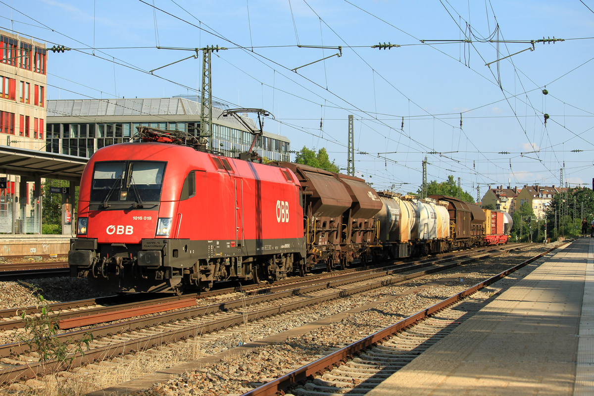Sehr fotogene Fahrzeuge, wie ich finde.
Die 1016 019 der �BB durchf�hrt mit einem seeeehr langen Mischer den M�nchener Heimeranplatz in Richtung Laim. Das Foto entstand am fr�hen Abend des 17.August 2018.