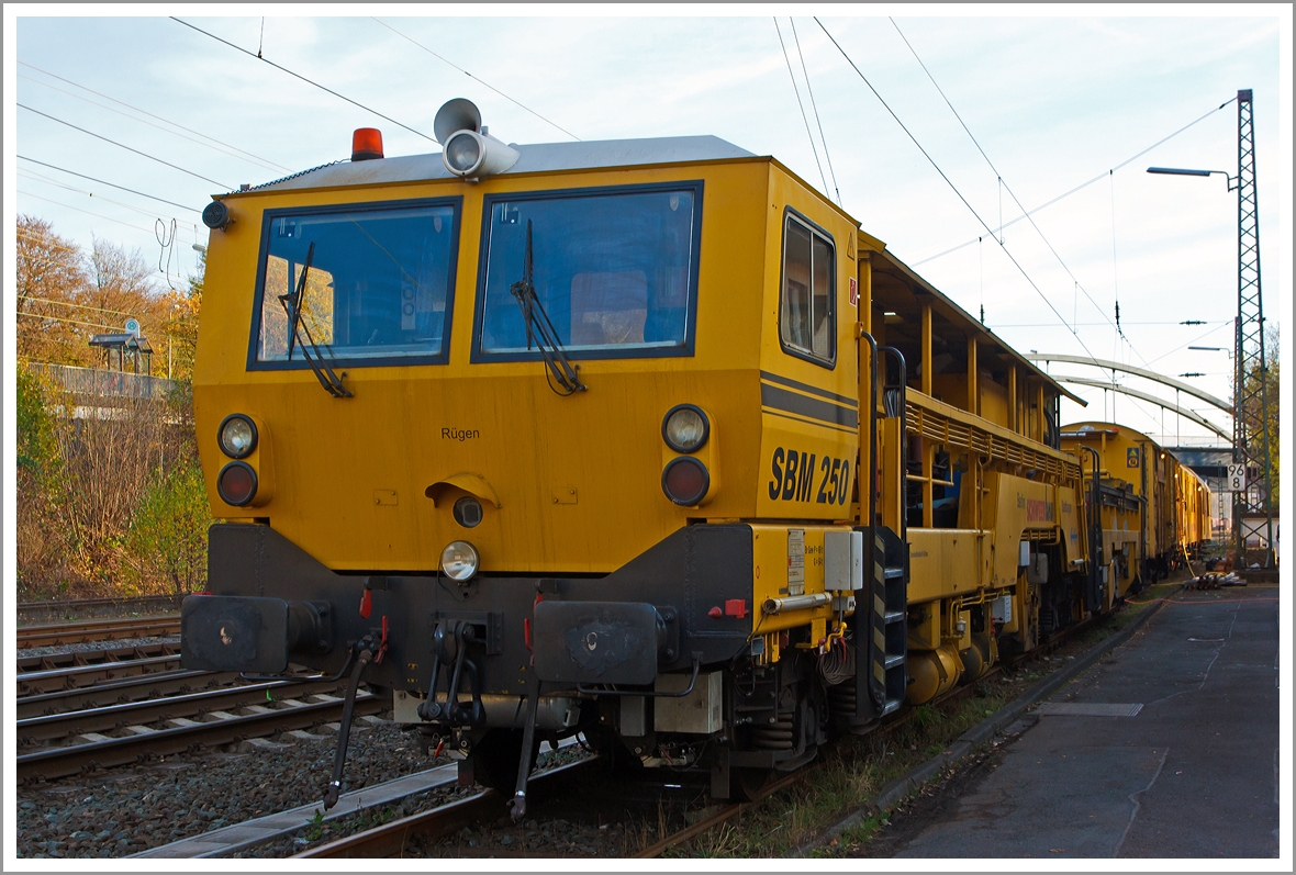 Sieht aus wie eine Stopfmaschine, ist es aber nicht, denn es ist...
Die Plasser & Theurer Schienenbearbeitungsmaschine SBM250 (Schienen-Hobelmaschine) der Schweerbau, Schweres Nebenfahrzeug Nr. 97 33 20 501 17-2, abgestellt am 16.11.2013 in Kreuztal.

F�r die Beseitigung sehr gro�er Schienenfehler und zur Beseitigung von Spurverengungen ist die Hobelmaschine SBM 250 nach wie vor die technisch beste und g�nstigste L�sung.

Die Maschine wurde von Plasser & Theurer  1993 unter der Fabriknummer 48 gebaut.

Technische Daten:
Eigengewicht: 95 t
Zul. Anh�ngelast: 40 t
L�nge �ber Puffer:  28.940 mm  
H�chstgeschwindigkeit: 90 km/h
Zur Mitfahrt zugel. Personen: 6
Zugelassene f�r Streckenklasse: C2 und h�her
