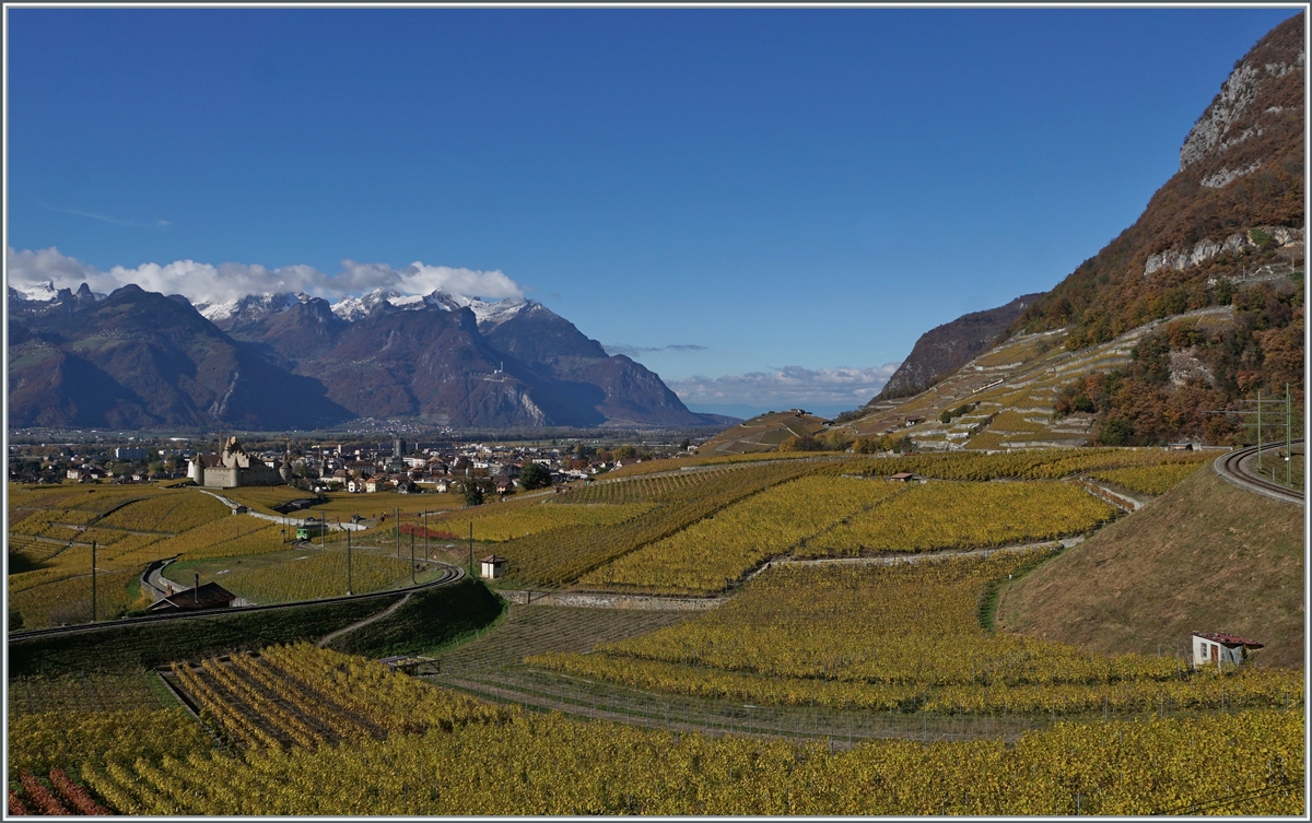 Viel Landschaft und etwas versteckt zwei Z�ge: Beim Schloss von Aigle ist TPC ASD BDe 4/4 402 als Regionalzug 435 von Plambuit nach Aigle unterwegs und im Hintergrund ist gerade noch der TPC AL BDeh 4/4 302 mit Bt 321 als Regionalzug 340 zwischen der Haltestelle Fontanney und Aigle D�p�t A-L zu erkennen .

5. November 2021