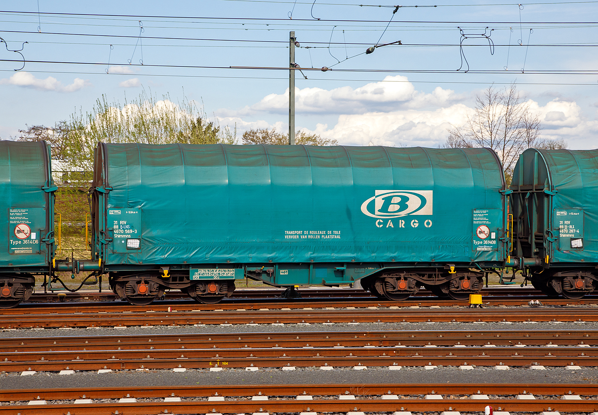 Vierachsiger Drehgestell-Flachwagen mit verschiebbarem Planenverdeck und Lademulden f�r Coiltransporte, 31 88 4670 569-3 B-LNS, der Gattung Shimmns (LINEAS Wagon Type 3614D8), der Lineas Group nv/sa (ex B-Logistics, ex B Cargo) am 14.04.2018 im Zugverband bei der Durchfahrt im Bahnhof Friedberg (Hessen).

Diese Wagen sind speziell f�r den Transport witterungsempfindlicher Blechrollen (Coils) bestimmt. Er besitzt feste Stirnw�nde, 5 fest im Untergestell eingebaute Lademulden. Die Wagenabdeckung erfolgt mit einer PVC-beschichteten Gewebeplane, die auf 11 Rohrrahmen aufliegt. �ber Laufwagen ist das Planendach in Wagenl�ngsrichtung verschiebbar. Die Verriegelung des Planendaches an den Stirnw�nden erfolgt �ber eine 4-Punkt-Zentralverriegelung, die sowohl vom Erdboden als auch von der Rampe aus bedient werden kann. Das Planenverdeck l�sst sich an einem Wagenende so weit zusammenschieben, dass ca. 2/3 der Ladefl�che zur Beladung freigegeben wird. Hierdurch ist eine einfache Beladung des Wagens sowohl von oben als auch von der Seite aus m�glich. 

TECHNISCHE DATEN:
Spurweite: 1.435 mm
Achsanzahl: 4 (in 2 Drehgestelle)
L�nge �ber Puffer: 12.040 mm
L�nge der Ladefl�che: 10.800 mm
Drehzapfenabstand: 7.000 mm
Achsabstand im Drehgestell: 1.800 mm
Eigengewicht: 22.300 kg
H�chstgeschwindigkeit:  100  km/h (beladen) / 120 km/h (leer)
Maximales Ladegewicht: 67,1 t (Streckenklasse D4)
Kleinster bef. Gleisbogenradius: 35 m
Bauart der Bremse: O-GP-A
Intern. Verwendungsf�higkeit: RIV

Bedeutung der Gattung Shimmns:
S     = Drehgestell-Flachwagen in Sonderbauart
h     = f�r den Transport liegend verladener Coils geeignet
i     = mit beweglicher Abdeckung und festen Stirnw�nden
mm    = Ladel�nge kleiner 15 m  (bei vierachsigen Wagen)
n     = Maximale Tragf�higkeit �ber 60 t
s     = H�chstgeschwindigkeit bis zu 100 km/h (beladen)
