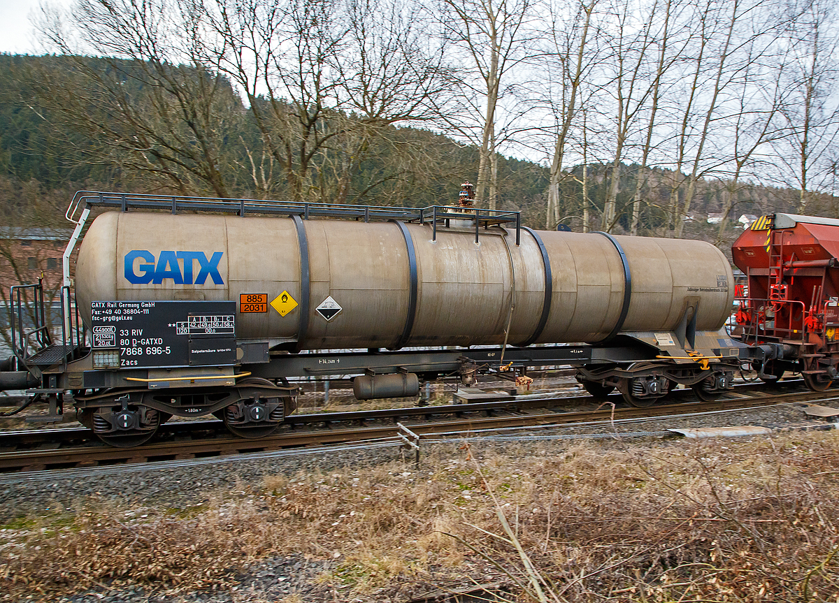 Vierachsiger-Drehgestell Kesselwagen für Salpetersäure (>98%), der Gattung Zacs, registriert als 33 80 7868 696-5 D- GATXD der GATX Rail Germany GmbH am 06.02.2017 in Herdorf, im Zugverband eines Übergabezuges der KSW.

Die Gefahrguttafel (885/2031)  zeigt es auch noch an: (oben) Gefahrgutnummer 885 = stark ätzender Stoff / (unten) UN-Nummer 2031 = Salpetersäure, andere als rotrauchend, mit mehr als 70 % Säurebrandfördernd. Hier sogar (laut Anschrift) größer 97 %.
Die reine Säure ist farblos und hat einen scharf stechenden Geruch. Sie wird unter anderem zur Herstellung von Sprengstoffen verwendet.

TECHNISCHE DATEN:
Gattung: Zacs
Spurweite: 1.435 mm
Länge über Puffer : 14.240 mm
Drehzapfenabstand: 9.200 mm
Achsabstand im Drehgestell: 1.800 mm
Höchstgeschwindigkeit: 100 km/h (120 km/h leer)
Eigengewicht: 21.530 kg
Nutzlast: 58,4 t ab Streckenklasse C
Gesamtvolumen: 44.900 Liter
Prüfdruck: 4 bar
Zulässiger  Betriebsüberdurck: 3 bar
Tankcode: L10DH
Behälterwerkstoff : Edelstahl
Bremse: KG-GP
Intern. Verwendungsfähigkeit:  RIV