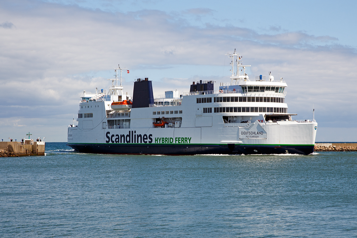 
Was hat ein Schiff mit Bahnbildern zu tun, ganz einfach es ist eine Eisenbahnfähre.
 
Die Deutschland fährt am 15.06.2015 in den Fährhafen Puttgarden ein.

Die Deutschland  ist eine kombinierte RoRo- und Eisenbahnfähre der Scandlines Deutschland GmbH, die seit 1997 auf der Vogelfluglinie eingesetzt wird.

Im Gegensatz zu ihren Vorgängern hat die Deutschland nur noch ein Gleis zur Aufnahme eines ICE TD oder zweier DSB MF. Der Transport von Güterwagen ist auf der Vogelfluglinie eingestellt worden. Das Schiff macht mit Haken in Höhe des Eisenbahndecks automatisch in den verbreiterten Fährbetten fest. Weil die Doppelendfähre die vorher üblichen Wendemanöver nicht mehr fahren muss, konnte die Fahrzeit um 25 % gekürzt werden und beträgt nur noch 45 Minuten.

Technische Daten:
Flagge: Deutschland
Schiffstyp 	Doppelendfähre
Länge über alles: 142,0 m
Breite: 24,78 m
Tiefgang: max. 6,0 m
Maschine (Dieselelektrischer Antrieb): 3 × MaK 8M32 und 2 MaK 6M32 Dieselmotoren mit Drehstromgeneratoren
Maschinenleistung: 15.840 kW (21.536 PS)
Dienstgeschwindigkeit: 18,5 kn (34 km/h)
Propeller: 	4 Propellergondeln
Transportkapazitäten
Zugelassene Passagierzahl: 1.200
Ladevolumen: 1 ICE TD oder 2 DSB MF sowie 40 Lkw oder 156 Pkw auf 625 m Länge plus 118 Pkw auf dem Autodeck
