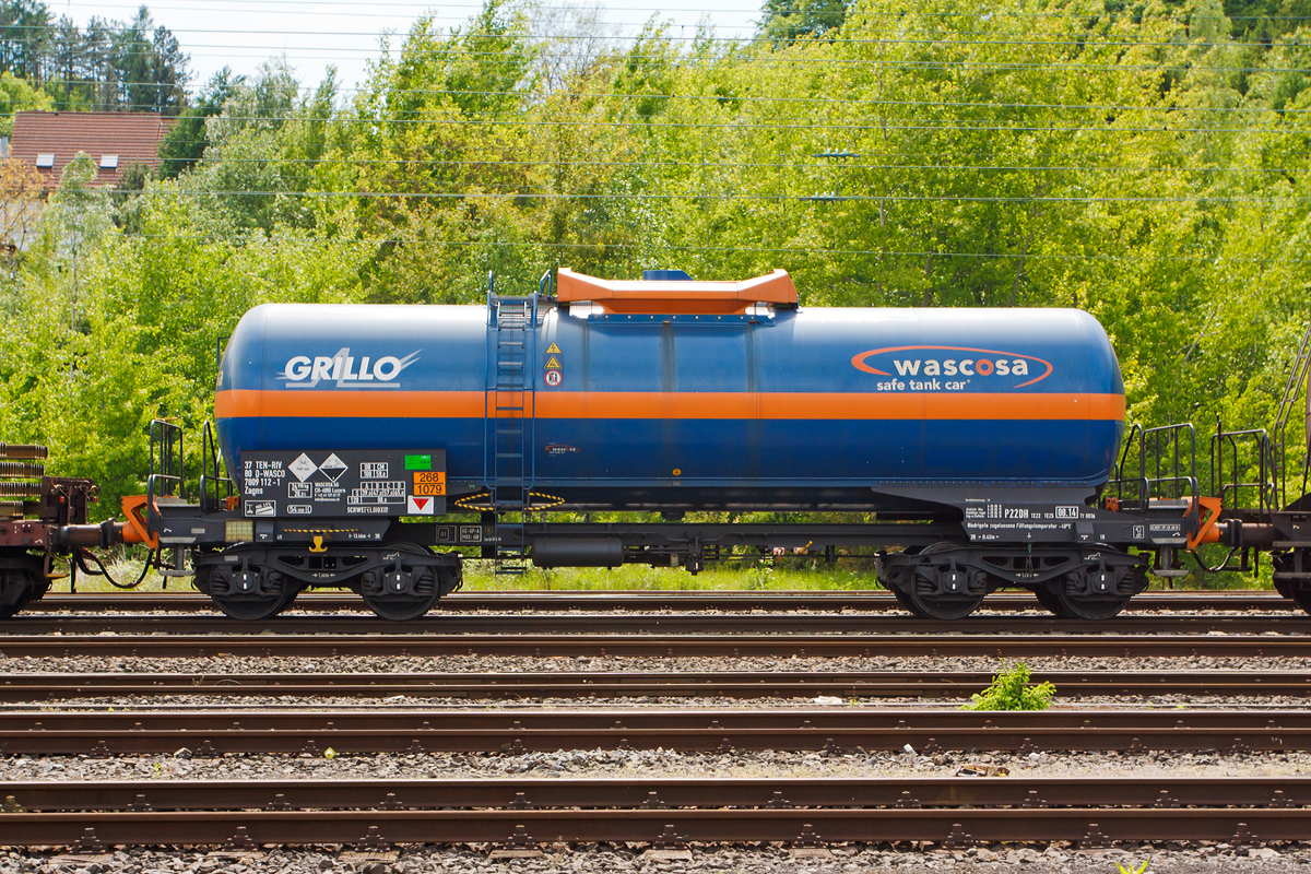 WASCOSA vierachsige Kesselwagen (54 m3) der Bauart Zagns (37 80 7809 112-1 D-WASCO) f�r/beladen mit Schwefeldioxid (der Grillo-Werke AG), Gefahrgut-Nr. 268/1079, bei der Fahrt im Zugverbund am 17.05.2012 durch Betzdorf/Sieg.

Ausgef�hrt als WASCOSA safe tank car�. Die WASCOSA AG ist ein Schweizer Wagonvermieter.

Der WASCOSA safe tank car� setzt einen neuen Sicherheits-Ma�stab im Transport von Gefahrgut auf der Schiene. Eine erste Serie des WASCOSA safe tank car� wird f�r den Transport von Schwefeldioxid eingesetzt. Mit seinen verschiedenen Sicherheitselementen und den optimierten �bergangsb�hnen an beiden Wagenenden verk�rpert dieser Wagentyp den Gefahrgutkesselwagen der Zukunft. Gemeinsam mit dem Kunden, G�terwagen- und Komponentenherstellern, Know-how-Tr�gern der Crash- und Simulations-Technologie sowie nicht zuletzt dem deutschen Eisenbahn-Bundesamt wurde ein v�llig neues Sicherheits- und Arbeitsschutzpaket entwickelt.

Zu den Sicherheitskomponenten geh�rt zum Beispiel ein v�llig neuer, zum Patent angemeldeter �berrollschutz. Ein weiteres Sicherheitselement sind die aus dem Lokomotivbau stammenden EST Suprapuffer G2. Das nach neuesten Erkenntnissen optimierte Kraftniveau und Deformationsverhalten dieser Puffer sch�tzt den Wagen mit verst�rktem Untergestell weit �ber das im RID geforderte Ma� hinaus.

Um gr��ere Sch�den bei Entgleisungen zu vermeiden, ist der Wagen mit zwei mechanischen Entgleisungsdetektoren ausger�stet. Zus�tzlich ist der Kesselwagen mit vier Aufkletterschutz-Modulen Typ AC04 der Firma EST ausger�stet, welche bei einem Unfall das Aufklettern der Puffer eines Wagens �ber die Puffer des benachbarten Wagens verhindern. Erstmals erf�llt dieser v�llig neu konzipierte �berpufferungsschutz die RID-Sondervorschrift TE25 Absatz a), die nicht nur fordert, den Kesselboden vor dem Eindringen von aufkletternden Gegenpuffern zu sch�tzen, sondern das Entstehen von Aufklettern bereits in der Anfangsphase zu verhindern.

Zur Arbeitssicherheit tr�gt eine optimierte �bergangsb�hne mit durchgehend uneingeschr�nkter Arbeitsgangbreite und zus�tzlichen Handgriffen am seitlichen Aufstieg bei. Wurde bei Neubau bisher nur ein Wagenende mit einer �bergangsb�hne ausgestattet, so bietet der WASCOSA safe tank car� dem Betriebspersonal an beiden Wagenenden eine sichere �bergangs- und Mitfahrm�glichkeit.

Technische Daten:
Eigengewicht: 24.990 kg
L�nge �ber Puffer: 13.460 mm
Drehzapfenabstand: 8.420 mm
Achsabstand im Drehgestell: 1.800 mm
Puffer EST Suprapuffer G2 - 100 MB
Drehgestelle: Y25 Lsd mit  K -Verbundsstoffbremsklotzsohlen
Rads�tze/Lagergeh�use: BA 004/182
Bremse: KNORR KE-GP A
H�chstgeschwindigkeit: 120 km/h leer / 100 km/h beladen
Tankinhalt: 54 m3 (54.000 l)
Tankcode: P22DH, mit Sondervorschriften TE 22 und TE 25
P= Tank f�r verfl�ssigte oder unter Druck gel�ste Gase
22 = zutreffender Mindestpr�fdruck in bar
D = Tank mit obenliegenden �ffnungen ohne �ffnungen unterhalb des Fl�ssigkeitsspiegels
H = luftdicht verschlossener Tank
Tankwerkstoff: Feinkornbaustahl P460 NL1