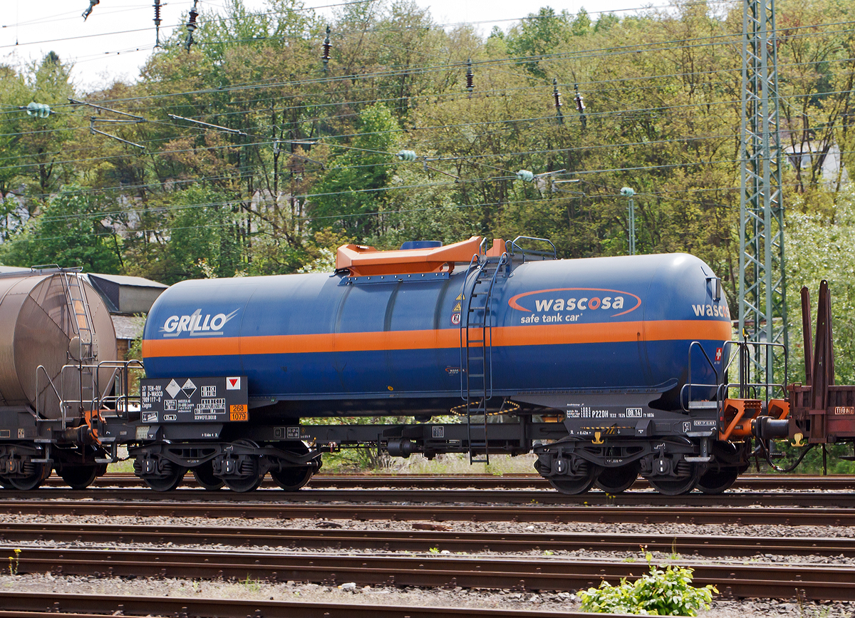 WASCOSA vierachsige Kesselwagen (54 m3) der Bauart Zagns (37 80 7809 117-0 D-WASCO) f�r/beladen mit Schwefeldioxid (der Grillo-Werke AG), Gefahrgut-Nr. 268/1079, bei der Fahrt im Zugverbund am 17.05.2012 durch Betzdorf/Sieg.

Ausgef�hrt als WASCOSA safe tank car�. Die WASCOSA AG ist ein Schweizer Wagonvermieter.

Der WASCOSA safe tank car� setzt einen neuen Sicherheits-Ma�stab im Transport von Gefahrgut auf der Schiene. Eine erste Serie des WASCOSA safe tank car� wird f�r den Transport von Schwefeldioxid eingesetzt. Mit seinen verschiedenen Sicherheitselementen und den optimierten �bergangsb�hnen an beiden Wagenenden verk�rpert dieser Wagentyp den Gefahrgutkesselwagen der Zukunft. Gemeinsam mit dem Kunden, G�terwagen- und Komponentenherstellern, Know-how-Tr�gern der Crash- und Simulations-Technologie sowie nicht zuletzt dem deutschen Eisenbahn-Bundesamt wurde ein v�llig neues Sicherheits- und Arbeitsschutzpaket entwickelt.

Zu den Sicherheitskomponenten geh�rt zum Beispiel ein v�llig neuer, zum Patent angemeldeter �berrollschutz. Ein weiteres Sicherheitselement sind die aus dem Lokomotivbau stammenden EST Suprapuffer G2. Das nach neuesten Erkenntnissen optimierte Kraftniveau und Deformationsverhalten dieser Puffer sch�tzt den Wagen mit verst�rktem Untergestell weit �ber das im RID geforderte Ma� hinaus.

Um gr��ere Sch�den bei Entgleisungen zu vermeiden, ist der Wagen mit zwei mechanischen Entgleisungsdetektoren ausger�stet. Zus�tzlich ist der Kesselwagen mit vier Aufkletterschutz-Modulen Typ AC04 der Firma EST ausger�stet, welche bei einem Unfall das Aufklettern der Puffer eines Wagens �ber die Puffer des benachbarten Wagens verhindern. Erstmals erf�llt dieser v�llig neu konzipierte �berpufferungsschutz die RID-Sondervorschrift TE25 Absatz a), die nicht nur fordert, den Kesselboden vor dem Eindringen von aufkletternden Gegenpuffern zu sch�tzen, sondern das Entstehen von Aufklettern bereits in der Anfangsphase zu verhindern.

Zur Arbeitssicherheit tr�gt eine optimierte �bergangsb�hne mit durchgehend uneingeschr�nkter Arbeitsgangbreite und zus�tzlichen Handgriffen am seitlichen Aufstieg bei. Wurde bei Neubau bisher nur ein Wagenende mit einer �bergangsb�hne ausgestattet, so bietet der WASCOSA safe tank car� dem Betriebspersonal an beiden Wagenenden eine sichere �bergangs- und Mitfahrm�glichkeit.

Technische Daten:
Eigengewicht: 24.850 kg
L�nge �ber Puffer: 13.460 mm
Drehzapfenabstand: 8.420 mm
Achsabstand im Drehgestell: 1.800 mm
Puffer EST Suprapuffer G2 - 100 MB
Drehgestelle: Y25 Lsd mit  K -Verbundsstoffbremsklotzsohlen
Rads�tze/Lagergeh�use: BA 004/182
Bremse: KNORR KE-GP A
H�chstgeschwindigkeit: 120 km/h leer / 100 km/h beladen
Tankinhalt: 54 m3 (54.000 l)
Tankcode: P22DH, mit Sondervorschriften TE 22 und TE 25
P= Tank f�r verfl�ssigte oder unter Druck gel�ste Gase
22 = zutreffender Mindestpr�fdruck in bar
D = Tank mit obenliegenden �ffnungen ohne �ffnungen unterhalb des Fl�ssigkeitsspiegels
H = luftdicht verschlossener Tank
Tankwerkstoff: Feinkornbaustahl P460 NL1