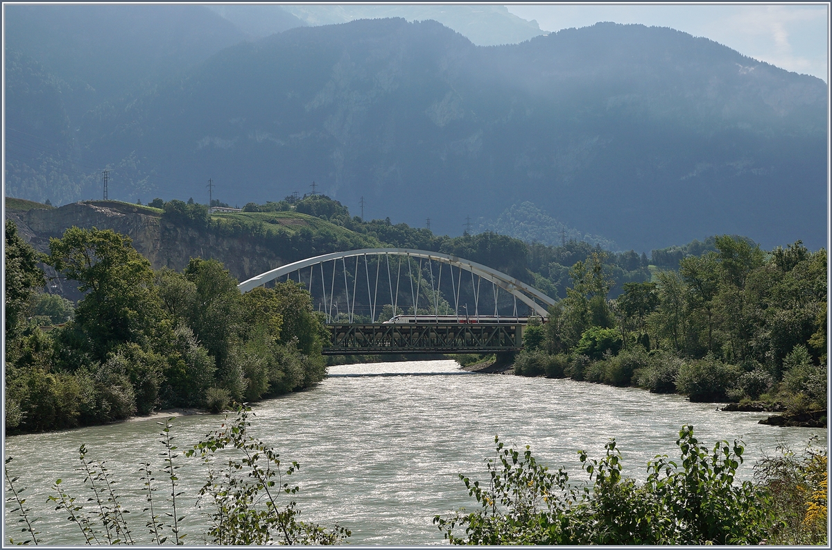 Zwischen Bex und St-Maurice �berquert die Strecke Lausanne Birg die Rhone. Die alte Gittereisenbr�cke wird nun durch eine sehr gef�llige und un�bersehbare Neukonstruktion ersetzt.
Zu Zeit ist die alte Br�cke schon nicht mehr in Betrieb und der Verkehr verl�uft einspurig �ber die neue Br�cke, wobei vor und nach der Br�cke das n�rdliche Gleis, dann auf der Br�cke das S�dliche Gleis benutzt wird, so dass die Br�cke noch verschoben werden muss.
Leider ist es nicht einfach, einen einigermasen guten Fotostandpunkt zu finden. 
Das Bild zeigt beiden Br�cken von S�den und (teilweise zu sehen) einen SBB ETR 610 auf dem Weg Richtung Lausanne.
19. August 2016   