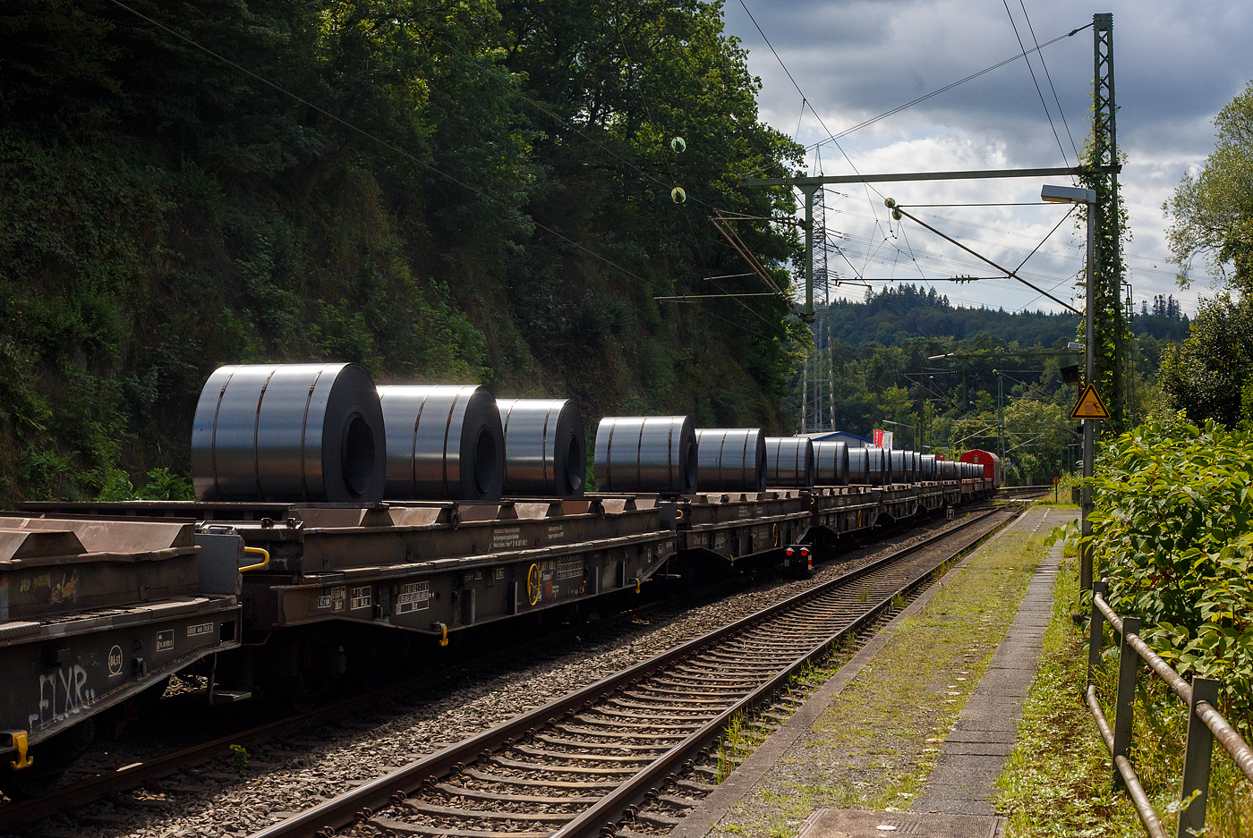 6-achsige Drehgestell-Flachwagen mit Lademulden für Coils (Blechrollen), hier im Vordergrund 31 80 4871 100-2 D-DB, der Gattung Sahmms-t 710, der DB Cargo Deutschland AG, am 08 August 2024 im Zugverband bei der Zugdurchfahrt in Scheuerfeld(Sieg), hier beladen mit 3 Warmband-Coils. 

Auf den eigentlichen Drehgestell-Flachwagen ist ein Ladegestell aufgesetzt, im dem sich 7 Lademulden für Coils befinden. Bei Bedarf kann das Ladegestell abgehoben werden und der Wagen kann so für andere Güter verwendet werden, dann würde der Wagen zur Gattung Samms 710. Früher wurden diese Wagen als Ssylms bzw. Sas 710 bezeichnet.

TECHNISCHE DATEN:
Spurweite: 1.435 mm (Normalspur)
Anzahl der Achsen: 6 in zwei Drehgestellen
Länge über Puffer: 16.400 mm
Drehzapfenabstand: 8.400 mm
Achsabstand im Drehgestell: 3.400 mm (2 × 1.700 mm)
Gesamter Radsatzstand: 11.800 mm
Ladelänge: 15.000 mm
Ladebreite in den Mulden (Sahmms-t): 2.450 mm
Max. Coil-Ø: 2.200 mm
Höchstgeschwindigkeit: 100 km/h (beladen) /120 km/h (leer)
Maximales Ladegewicht: 84,5 t (Streckenklasse CE oder höher) / Intern. 69,5 t (ab Streckenklasse D)
Eigengewicht: 35.370 kg
Achslast: 20 t
Kleinster bef. Gleisbogenradius: 80 m
Bauart der Bremse: KE-GP
Handbremse: Fbr
