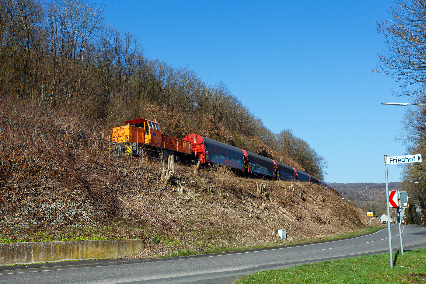 Am Zugschluss die nachschiebende KSW 45 (98 80 0276 016-9 D-KSW) eine MaK G 1204 BB der KSW (Kreisbahn Siegen-Wittgenstein). Sie schieb am 19 März 2025 den schweren Coilzug von Betzdorf/Sieg in Richtung Herdorf zum KSW-Rangierbahnhof (Betriebsstätte FGE - Freien Grunder Eisenbahn) nach, hier bei Herdorf-Sassenroth.