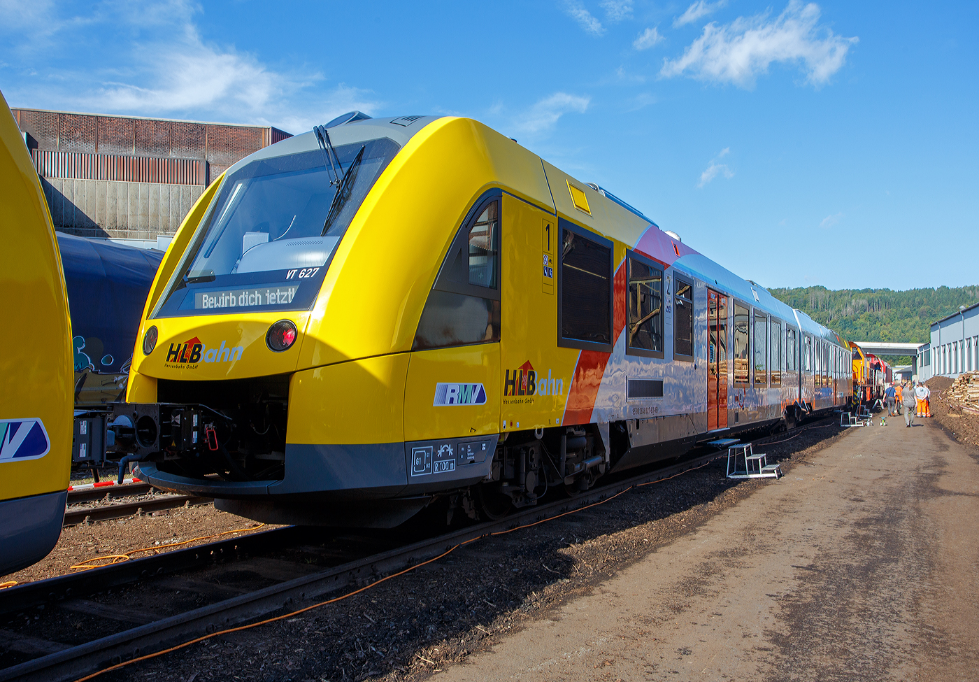 An diesem Wochenende war bundesweit an vielen Orten im Rahmen der  Europ�ische Mobilit�tswoche   der „Tag der Schiene 2023“ so auch in Siegen beim KSW Bahnhof Siegen-Eintracht war am 17.09.2023 Tag der offenen T�r, hier war u.a. ausgestellt:
Der nagelneue VT 627 (95 80 2648 027-6 D-HEB / 95 80 2648 527-5 D-HEB) der HLB (Hessische Landesbahn GmbH), ein Alstom Coradia LINT 41 der neuen Generation und leistungsst�rkeren Antrieb (140 km/h).

Der Dieseltriebzug wurde 2023 ALSTOM Transport Deutschland GmbH (vormals LHB) in Salzgitter-Watenstedt unter der Fabriknummer D041475-027 gebaut und an die HLB (f�rs Teilnetz Wetterau / Standort Butzbach) geliefert. 

F�r das Teilnetz Wetterau West-Ost hat die HLB 2020 bei Alstom 30 Coradia Lint 41 Regionalz�ge bestellt. Der Auftrag hat einen Wert von 120 Millionen Euro. Die Z�ge mit 120 Sitzpl�tzen sind gro�z�gig und hell eingerichtet, behindertengerecht ausgestattet und bieten dank ihrer gro�en Fenster ein einzigartiges Reiseerlebnis. Diese LINT 41 verf�gen �ber je zwei Mehrzweckbereiche f�r Rollst�hle, Kinderwagen und Fahrr�der sowie �ber barrierefreie Universaltoiletten. Zudem sind die Z�ge mit WLAN, Steckdosen am Platz, einem Fahrgastinformationssystem mit Monitoren f�r Echtzeitdaten, sowie Video�berwachung zur Gew�hrleistung einer hohen Fahrgastsicherheit ausgestattet. Die verbrauchsarmen Dieselfahrzeuge entsprechen bereits der strengsten EU-Abgasnorm Stage V.

Diese Coradia Lint Regionalz�ge erreichen eine maximale Betriebsgeschwindigkeit von 140 km/h (anstelle 120 km/h) und verf�gen �ber eine hohe Beschleunigung. Sie sollen vorwiegend auf den Strecken Gie�en – Gelnhausen, W�lfersheim-S�del – Friedberg (– Frankfurt), Nidda – Friedberg (– Frankfurt) verkehren. 

Alstom Coradia Lint-Z�ge fahren seit dem Jahr 2000 in mehr als 30 Netzen in Deutschland, Europa und Kanada. Weltweit wurden bisher rund 1.100 Fahrzeuge verkauft. 

Eigentlich m�ssten diese LINT mit der neuen Kopfform ja LINT 42 hei�en, da sie mit einer L�nge von 42,17 m etwas l�nger sind als die urspr�nglichen LINT 41 (41,81 m). Denn die Bezeichnung LINT 41 bedeutet „leichter innovativer Nahverkehrstriebwagen“, die 41 steht f�r die L�nge der vollen Meter (bei dem urspr�nglichen 41,81 m). Wird die Bezeichnung „H“ (LINT 41/H) verwendet, so sind es Hochflur-Fahrzeuge. Dies hier sind aber zweiteilige Niederflur-Dieseltriebwagen, welches man gut an der bis unten gehenden T�r erkennen kann.  

Die LINT-Triebwagen sind in Stahlbauweise ausgef�hrt. Bei den LINT 41 wird pro Wagenkasten ein Enddrehgestell von einer dieselmechanischen Antriebsanlage mit liegend eingebauten MTU-Reihen-Sechszylinder-Dieselmotoren mit  Leistung von 400 kW �ber eine Gelenkwelle angetrieben. Bis zu drei Einheiten sind �ber die automatische Scharfenbergkupplung Typ 10 zu einem Zug kuppelbar.

Als Bremsen werden druckluftbet�tigte Scheibenbremsen verwendet, an je einem Triebdrehgestell befinden sich zus�tzlich Magnetschienenbremsen. Als Feststellbremse sind Federspeicher vorhanden. Die Bremsanlagen ist von Knorr-Bremse. Die Fahrzeuge der HLB (wie auch die DB Regio) verwenden zudem Retarder als hydrodynamische Erg�nzungsbremse. Die Fahrzeuge verf�gen zus�tzlich �ber Ru�partikelfilter.

Die Fahrzeuge verf�gen �ber voneinander unabh�ngige F�hrerraumklimaanlagen und Fahrgastraumklimaanlagen. Je Wagenkasten sind zwei Dachklimager�te vorhanden. Die Abw�rme der Dieselmotoren wird zur Beheizung von Fahrgastr�umen und F�hrerr�umen genutzt. Reicht die Abw�rme nicht aus, so werden dieselbefeuerte Zusatzheizger�te zugeschaltet. Geliefert wird die Heizungs-, L�ftungs-, Klimaanlage von „Spheros“ (ehemals Webasto).

Die Steuerschr�nke im F�hrerraum werden als Sonderl�sung von Rittal produziert und von Alstom ausger�stet.

TECHNISCHE DATEN:
Hersteller: 	Alstom Transport Deutschland GmbH
Baureihe: 	2648
Art: Diesel-hydromechanischer Niederflurtriebwagen
Fahrzeugbestand bei der HLB: 30
Spurweite: 1.435 mm (Normalspur)
Radsatzfolge: Bx’ (2) By’
L�nge: 42.170 mm
Breite: 2.750 mm
Drehzapfenabstand: 16.500 mm
Achsabstand im Drehgestell (Antriebsgestelle): 1.900 mm
Achsabstand im Drehgestell (Jakobsgestell): 2.700 mm
Eigengewicht: 79,0 t
Geschwindigkeit: 140 km/h
Leistung: 2 x 400 kW
Sitzpl�tze: 120, davon 10 in der 1. Klasse
Niederfluranteil: 60 %
Kupplungstyp: Scharfenbergkupplung Typ 10
Kleinster befahrbarer Gleisbogen: R = 100 m
Bremse: KB C-pn-R-A-H (D)
