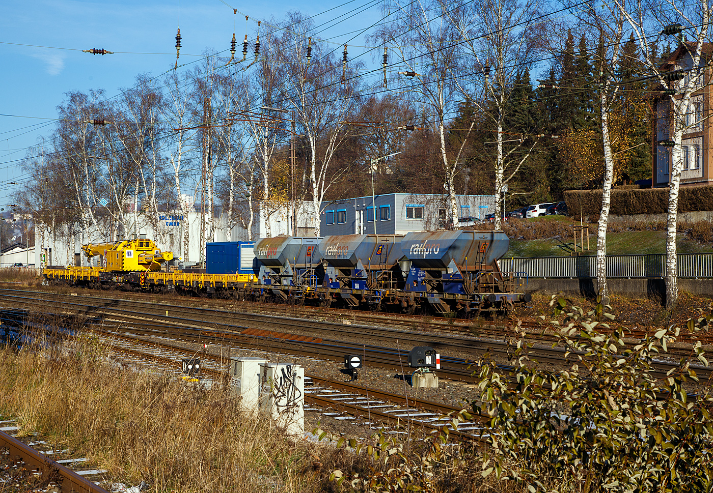 Der 125t Gleisbauschienenkran (Gleis- und Br�ckenbaukran) - KIROW Multi Tasker KRC 910, Kran 3 der MGW Gleis- und Weichenbau-GmbH & Co.KG (Berlin), Schweres Nebenfahrzeug Nr. D-MGWB 99 80 9419 025-8, ist in Transportstellung mit dem Schutzwagen gegenlastseitig (Gegengewichtwagen) 33 56 3999 005-0 SK-BUG (Gattung Res) und dem Schutzwagen auslegerseitig 33 80 3998 047-3 D-BUG (Gattung Res), am 30.10.2022 in Kreuztal abgestellt. Davor 3 zweiachsige Sch�ttgutwagen f�r Schotter der Gattung NS Fccpps der  Railpro.

Der Kran wurde 2018 von der Kirow Ardelt GmbH (Leipzig) unter der Fabriknummer  MT2017170871  gebaut und an die MGW geliefert.

TECHNISCHE DATEN:
Eigengewicht: 104 t (in Transportstellung)
L�nge �ber Puffer: 13.000 mm (ohne Kranausleger), in Transportstellung mit den beiden Schutzwagen 13.000 mm + 2x19.900 mm = 52.800 mm
Achsanzahl: 8
Drehzapfenabstand: 8.000 mm
Drehzapfenabstand im Drehgestell 1 und 2: 2.300 mm
Achsabstand in den Einzeldrehgestellen: 1.100mm
Ergebene Achsabst�nde in m: 1,1 / 1,2 / 1,1/ 4,6 / 1,1 / 1,2 / 1,1
Achsfolge: 1'A'1A' A1'A1'
Lauf-  und Treibraddurchmesser: 730 mm (neu)
Achslast: 13,0 t (Streckenlast 8,0 t/m)
Zugelassene Streckenklasse: CE oder h�her
Dieselmotor: Wassergek�hlter Cummins 6-Zylinder Reihenmotor mit Partikel-Filter
Motorleistung: 200 kW
Not-Dieselmotor: Luftgek�hlter 2-Zylinder Viertakt-Dieselmotor mit Direkt-Einspritzung vom Typ Hatz 2 G 40 mit einer Leistung16 kW bei 3000 U/min
Fahrgeschwindigkeit im Zugverband: 100 km/h
Fahrgeschwindigkeit mit Eigenantrieb: 19 km/h
Zul. Anh�ngelast: 160 t
kleinster befahrbarer Radius: 80 m
Bremse: KE-GP mZ
Max. Tragf�higkeit abgest�tzt: 100 t
Max. Tragf�higkeit freistehend: 90 t
Max. Traglast bei max. Ausladung: 23 t
Max. Hakenh�he: 21.000 mm