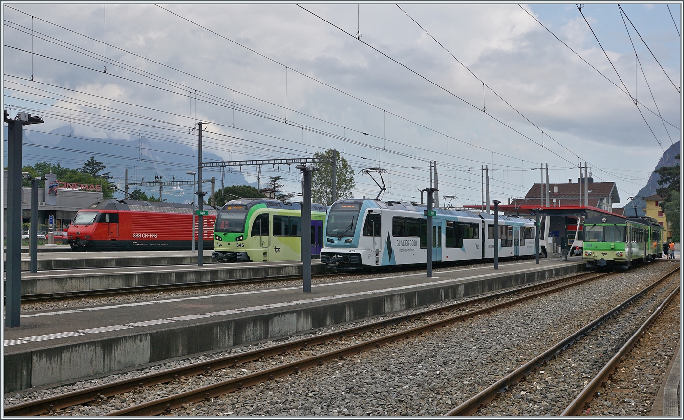 Der Bahnhof von Aigle mit TPC Zügen in alle Richtungen: Der TPC Beh 2/6 545 wird als R72 130 nach Monthey fahren, der neue TPC ASD ABe 4/8 473  Glacier 3000  als R 71 432 nach Les Diablerets und der A-L BDeh 4/4 mit Bt 361 als R 70 332 nach Leysin Grand Hotel.
Zudem ist im Hintergrund eine SBB Re 460 zu erkennen, welche einen IR 90 in Richtung Lausanne schiebet. 

3. Aug. 2024 