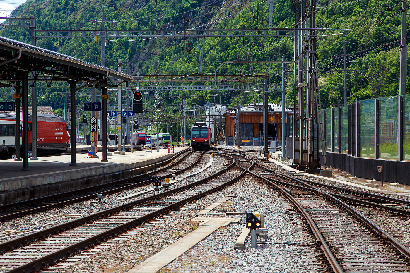 Der dreiteilige NPZ Domino RA12 der RegionAlps (ex SBB RBDe 4/4) erreicht am 25.05.2023 als Regio (St-Gingolph–St-Maurice –Martigny–Sion–Brig), Steuerwagen voraus, seinen Zielbahnhof Brig.

Der NPZ Domino besteht aus:
1./2. Klasse Steuerwagen ABt NPZ DO RA 50 85 39-43 948-1 CH-RA
Modernen 2.Klasse INOVA-Zwischenwagen mit Niederfluranteil B NPZ DO RA 50 85 29-43 407-0 CH-RA
und dem 
Triebwagen RBDe 560 DO RA 94 85 7 560 412-9 CH-RA, ex SBB RBDe 560 010-1 (Umbau 2009).

Die Regionalps (RA) ist ein Eisenbahnverkehrsunternehmen im Kanton Wallis, mit Sitz in Martigny hat. Eigent�mer derim Jahr 2003 gegr�ndete Gesellschaft  sind die Schweizerischen Bundesbahnen (SBB) mit 70 %, die Transports de Martigny et R�gions (TMR) mit 18 % und der Kanton Wallis mit 12 %. Die RA betreibt den Regionalverkehr vor allem im Rhonetal zwischen dem Ostufer des Genfersees und Brig. Inzwischen geh�ren Regionalps 16 dreiteilige NPZ Domino (Trieb-, Zwischen- und Steuerwagen ex SBB) und 4 RABe 525 NINA (ex TMR).