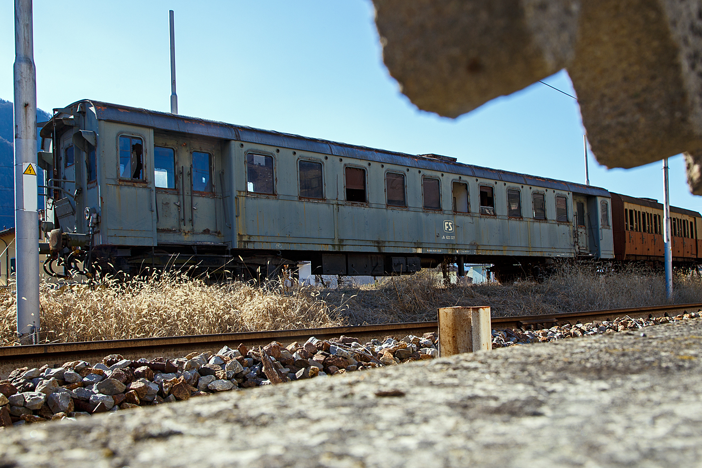 Der FS pBz 623 327 ein Steuerwagen zu den Triebwagen der Baureihen E.623 (Automotrice elettrica E.623 - Rimorchi pBz 623) abgestellt am 19 Februar 2017 in Tirano, leider hier im Gegenlicht. Hätte ich damals gewusst was ich hier aufgenommen habe, so wäre ich am Nachmittag nochmal dort hingegangen. 

Die schweren Elektrotriebwagen E.623 der italienischen Ferrovie dello Stato (FS) waren Elektrotriebwagen, die anfangs der 1950er Jahre aus den für die Ferrovie Varesine gebauten Triebwagen der Baureihen E.10 und E.60 umgebaut wurden. Auch die zugehörigen Steuerwagen (eCiz 300-342)
wurden zu pBz 623 327 – 342 umgebaut, die 3. Wagenklasse wurde dabei in die 2. Wagenklasse geändert. 

Die ursprünglich für den Betrieb mit 650 V Gleichstrom aus der Stromschiene gebauten Fahrzeuge erhielten die Triebwagen nun zwei Scherenstromabnehmer auf dem Dach für Stromaufnahme aus der Oberleitung, zudem angepasste elektrische Ausrüstung, damit sie auf den nun mit 3 kV-Fahrleitung elektrifizierten Strecken verkehren konnten. Durch den Umbau vergrößerte sich auch das Einsatzgebiet der Varesine genannten Triebwagen. Sie verkehrten außerhalb ihrer Stammstrecke auch von Mailand nach Domodossola, Bergamo und Novara, sowie auf der Strecke von Novara nach Alessandria. Weiter wurden von Novara aus auch Luino und Arona, sowie auf der Strecke Seregno–Carnate mit Varesine bedient. Zwei Triebwagen sind im historischen Fahrzeugpark der FS-Stiftung erhalten.

TECHNISCHE DATEN (Steuerwagen pBz):
Ur-Baujahre: 1931 bis 1932
Hersteller: Breda - CGE
Spurweite: 	1.435 mm (Normalspur)
Achsformel: 2'2' 
Länge über Puffer: 21.050 mm 
Drehzapfenabstand:  14.200 mm
Achsabstand im Drehgestell: 2.500 mm
Laufraddurchmesser: 1.010 mm (neu)
Eigengewicht: 41 t
Höchstgeschwindigkeit: 120 km/h (ursprünglich 110 km/h)
Sitzplätze: 70 (in der 2. Klasse)
Bremse: Freno WU-P
