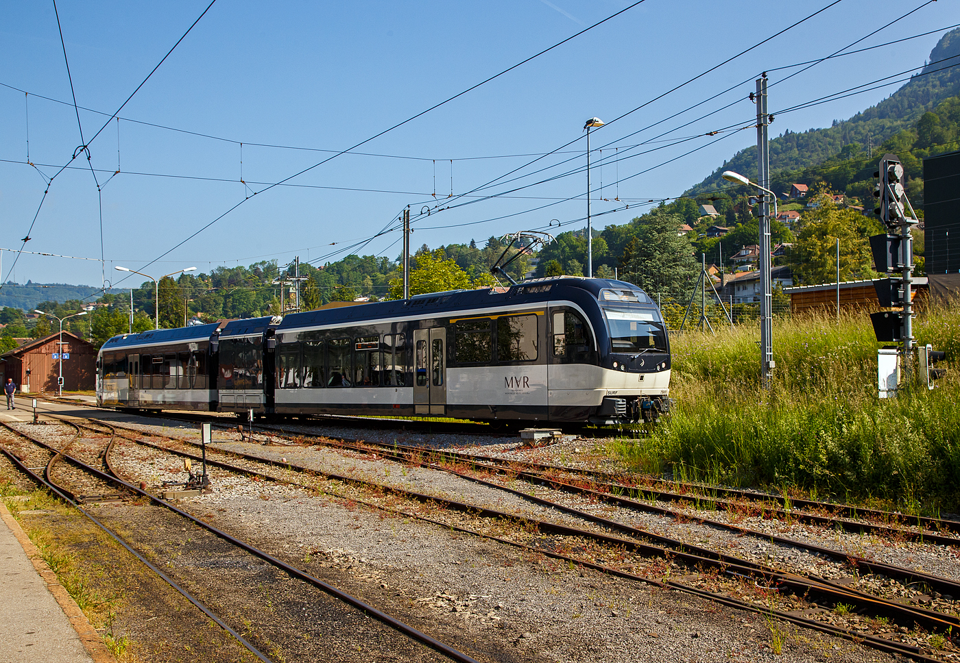 Der von der Gipfelstation Les Pl�iades kommende MVR (ex CEV) SURF ABeh 2/6 7508 hat gerade den Zahnradanschnitt verlassen und erreicht nun den Bahnhof Blonay. Nachdem Halt f�hrt er dann weiter hinab nach Vevey.

SURF steht f�r S�rie Unifi�e Romande pour R�seau Ferr� m�trique (Einheitliche Serie f�r das Westschweizer Meterspurige Schienennetz). Diese ab 2015 gebaute meterspurige Triebz�ge mit gemischtem Adh�sions- und Zahnradbetrieb geh�ren zu den Stadler GTW der 4. Generation.

