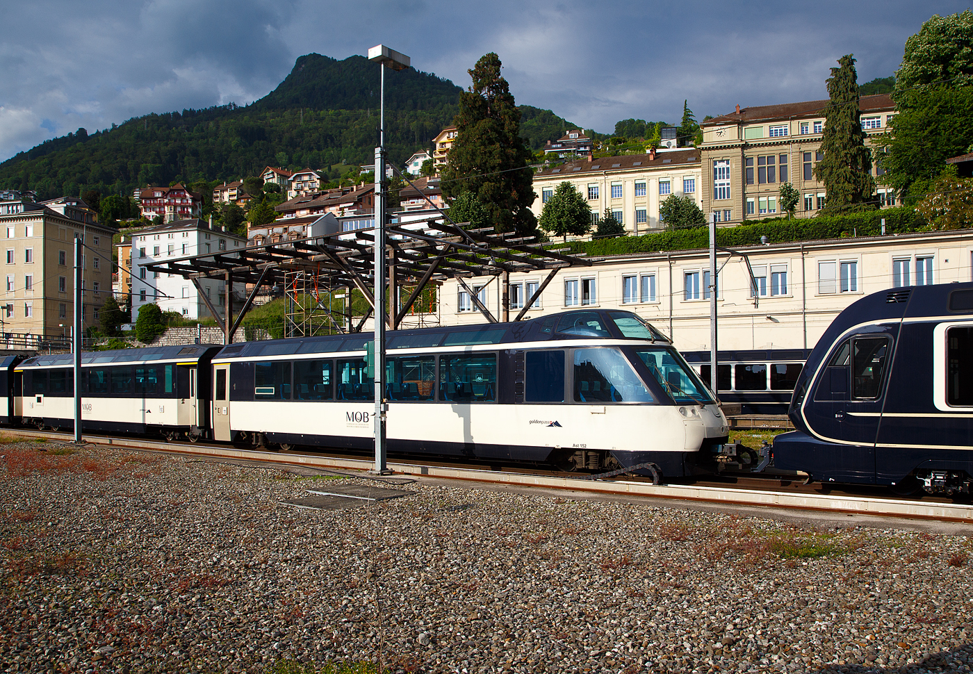 Der vierachsige MOB 1.Klasse Panorama-Steuerwagen Ast 152 „goldenpass“  (ex Arst 152  Panoramic Express -Wagen) ist am 26. Mai 2023 beim Bahnhof Montreux abgestellt.

Die MOB beschaffte 1993 zwei Panoramawagen als Steuerwagen Arst 151–152 mit erh�htem F�hrerstand und 8 Aussichtspl�tzen hinter der Frontscheibe, diese Passagiere k�nnen so den Blick nach vorne auf die Strecke (bei entspr. Fahrtrichtung) genie�en. Die beiden Wagen Ast 151 und 152 und die beiden As 153 und 154, wurden mit einer GDe 4/4 in der Mitte, als reiner 1. Klasse-Zug Crystal Panoramic anstelle des Superpanoramic am Wochenende und im Sommer t�glich eingesetzt.

Der �brige Passagierraum war urspr�nglich ist als Barwagen mit L�ngssitzb�nken ausgestattet. Auf Tische wurde verzichtet und die Sitze am Wagenende in Reihenbestuhlung angeordnet.

TECHNISCHE DATEN:
Hersteller: Breda, Baujahr 1993, sowie MOB und SIG (Drehgestelle)
Spurweite: 1.000 mm (Meterspur)
Achsanzahl: 4 (in 2 Drehgestellen)
L�nge �ber Puffer: 18.700 mm
Wagenkastenl�nge: 18.060 mm
Drehzapfenabstand: 12.830 mm
Achsabstand im Drehgestell: 1.800 mm
Drehgestell Typ: SIG-90
Laufraddurchmesser: 750 mm (neu)
Eigengewicht: 20,7 t
H�chstgeschwindigkeit: 120 km/h
Sitzpl�tze: 28 (in der 1. Klasse) und 8 (VIP)
WC: 1
Kupplung: Automatischen SCHWAB Kupplung