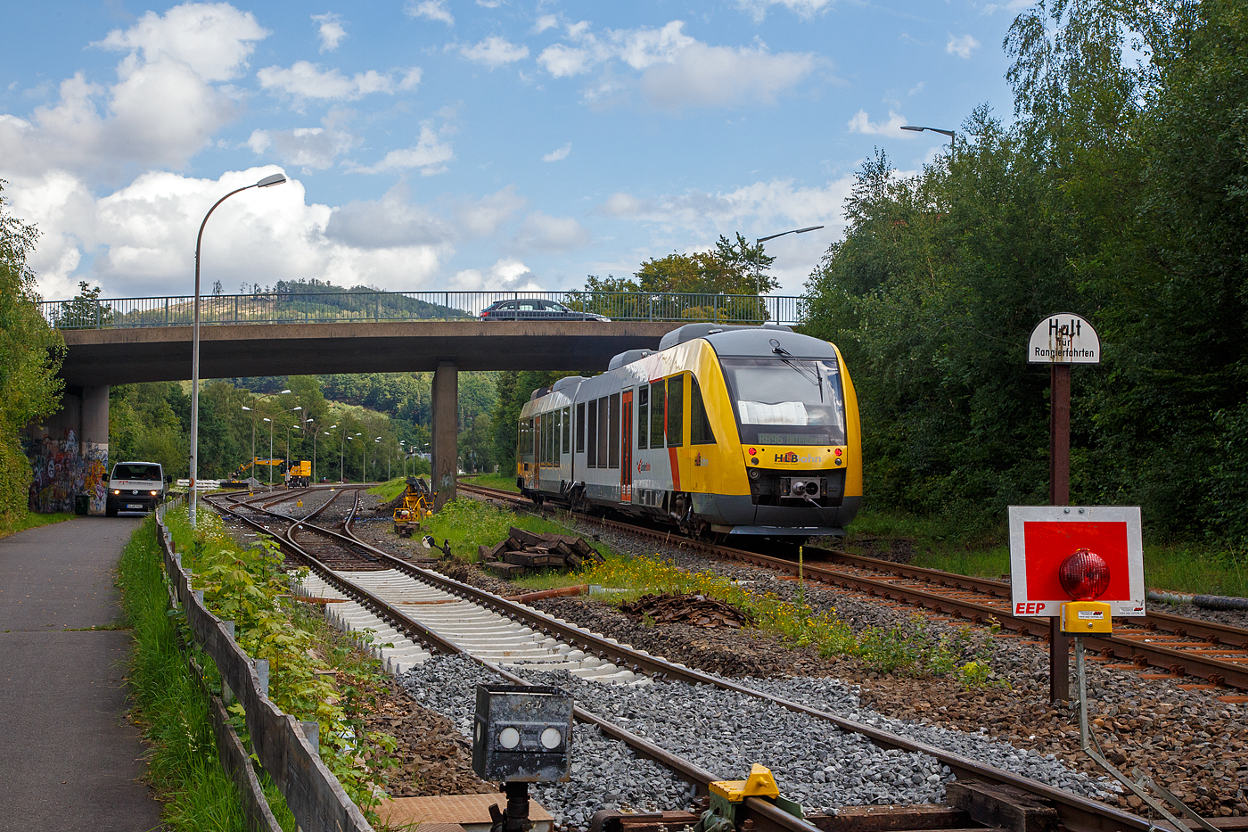 Der VT 263 (95 80 0648 163-3 D-HEB / 95 80 0648 663-2 D-HEB) ein Alstom Coradia LINT 41 der HLB (Hessische Landesbahn), verlässt am 16.08.2023, als RB 96 „Hellertalbahn“ (Betzdorf – Dillenburg), Herdorf und fährt weiter in Richtung Neunkirchen/Siegerland. Eigentlich fahren auf dieser Verbindung die „neuen“ LINT 41, aber hier war es nochmal ein alter. 

Links vorne sieht man die KSW (Kreisbahn Siegen-Wittgenstein) erneuert die ersten Gleismeter vom Anschlussgleis, zum Rangierbahnhof in Herdorf der Betriebsstätte FGE -Freien Grunder Eisenbahn (KSW NE447 / DB-Nr. 9275).
