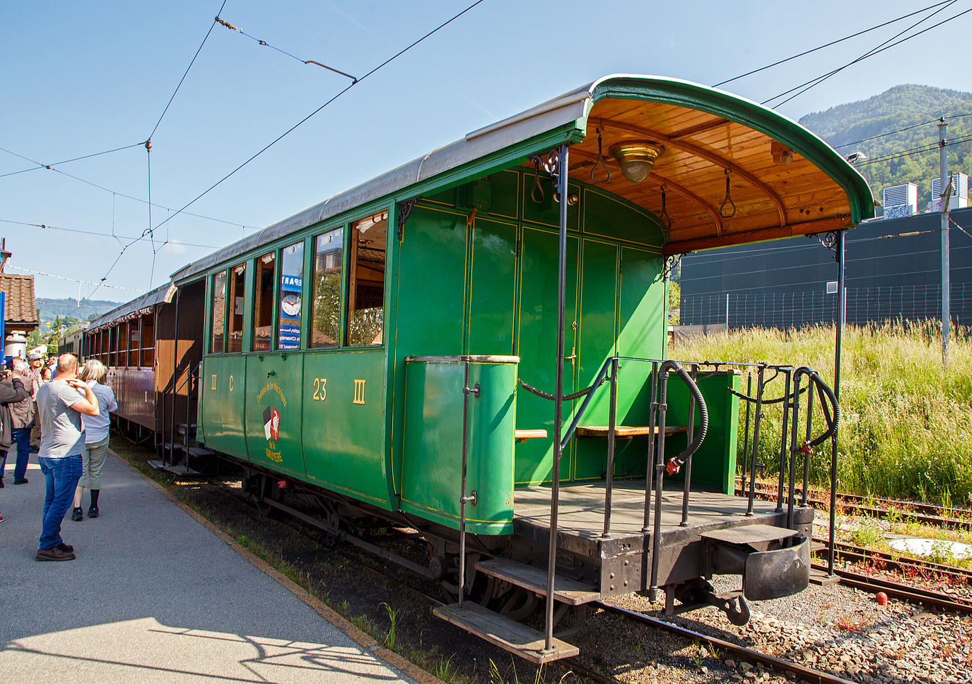 Der zweiachsige 3. Klasse Personenwagen mit offenen Plattformen (Plattformwagen) ex CEG C� 23 (Chemins de fer Electriques de la Gruy�re, ab 1942 GFM - Chemins de fer fribourgeois Gruy�re–Fribourg–Morat) der Museumsbahn Blonay-Chamby am 27.05.2023 im Zugverband im Bahnhof Blonay.

Der Wagen wurde 1903 von der SWS (Schweizerische Wagons- und Aufz�gefabrik AG, Schlieren) f�r die Chemins de fer �lectriques de la Gruy�re (CEG) gebaut und als CEG C� 23 geliefert. Im Jahr 1967 ging der Wagen an die Museumsbahn Blonay-Chamby.

Die Chemins de fer �lectriques de la Gruy�re schloss sich 1942 mit den beiden Normalspurbahnen FMA und BR zur GMF (Chemins de fer fribourgeois Gruy�re–Fribourg–Morat) zusammen. Seit 2000 nun TPF (Transports publics fribourgeois SA / Freiburgische Verkehrsbetriebe AG).

TECHNISCHE DATEN:
Baujahr: 1903
Hersteller: SWS Schlieren (Schweizerische Wagons- und Aufz�gefabrik AG)
Spurweite: 1.000 mm (Meterspur)
Achsanzahl: 2
L�nge �ber Puffer: 8.900 mm
L�nge Wagenkasten: 7.900 mm (mit Plattformen)
Achsabstand: 4.300 mm
Eigengewicht: 7,3 t
Sitzpl�tze: 23 in der 3. Klasse