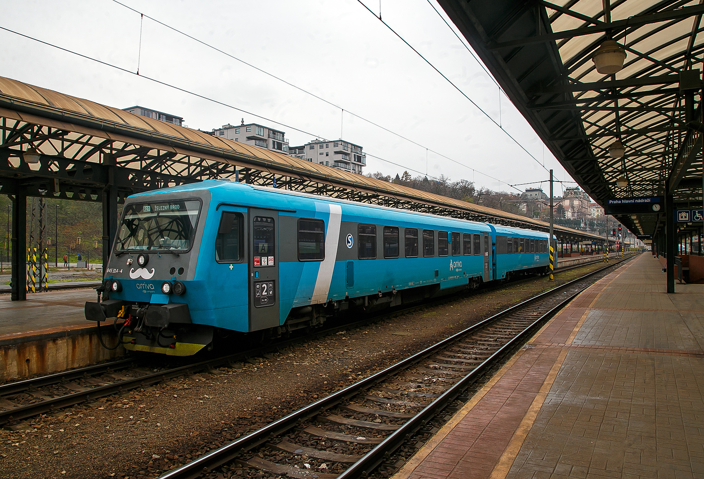 Der zweiteilige Dieseltriebzug 845 314-4 / 945 314-2 (95 54 5845 314-4 CZ-ARR / 95 54 5945 314-2 CZ-ARR) der ARRIVA vlaky s.r.o., Praha / Prag (eine Tochter der DB AG), ex DB 628 218-0 / DB 928 218-7, steht am 23.11.2022, als R21 nach Železný Brod, im Prager Hauptbahnhof (Praha hl.n.), zur Abfahrt bereit.

Der Dieseltriebzug wurde 1987 von der Düsseldorfer Waggonfabrik AG (DUEWAG) unter den Fabriknummern 88664 und 88665 gebaut und an die Deutsche Bundesbahn geliefert. Bis Februar 2019 war er, als 95 80 0628 218-9 D-DB / 95 80 0928 218-6 D-DB im Bestand der der DB Regio AG (RheinNeckar), dann wurde er an die tschechische DB-Tochter ARRIVA vlaky s.r.o. verkauft und durch Pars Nova a.s. (ab 2021 ŠKODA PARS a.s) modernisiert.

Seit 2012 wurden 43 Triebwagen an die tschechische DB-Tochter Arriva vlaky verkauft. Sie wurden in den Hausfarben Türkis (teilweise auch Hellgrün und Beige) lackiert und werden als Baureihe 845 / 945 geführt. Damit werden seit Dezember 2016 eigenwirtschaftlich Verkehre angeboten. Mit dem Gewinn von mehreren Ausschreibungen werden seit Dezember 2018 vermehrt Triebwagen erforderlich. Dafür werden weitere Triebwagen durch Pars Nova modernisiert. Sie erhalten neue Sitze, Steckdosen, eine behindertengerechte Toilette und WLAN. Neben den schon genannten Änderungen und einer zweiten Toilette hat er auch Displays an den Ausgängen zur Fahrgastinformation, und ein Abteil, von dem aus Getränke und Snacks verkauft werden. Diese Triebwagen werden als Baureihe 845.3 / 945.3 eingeordnet. 

Altere Modernisierungen der BR 845.1 und 845.2  haben noch keine behindertengerechte Toilette, welche aber bei den kommenden Renovierungen als zweite Toilette eingebaut werden soll.

TECHNISCHE DATEN:
Anzahl: 49 (21 davon als BR 845.3 / 945.3)
Hersteller: DUEWAG
Modernisierung durch Pars Nova a.s. (ab 2021 ŠKODA PARS a.s)
Spurweite: 1.435 mm (Normalspur)
Achsformel: 2’B’ + 2’2’
Länge über Kupplung:  45.400 mm (2× 22.700 mm)
Dienstgewicht: 68 t (40 t und 28 t)
Höchstgeschwindigkeit: 120 km/h
Dieselmotor: V-12 Zylinder Daimler-Benz OM 444A
Installierte Leistung: 410 kW
Leistungsübertragung: hydrodynamisch	
Kupplungstyp: Schaubkupplung
Sitzplätze: 134 (62 und 72)
